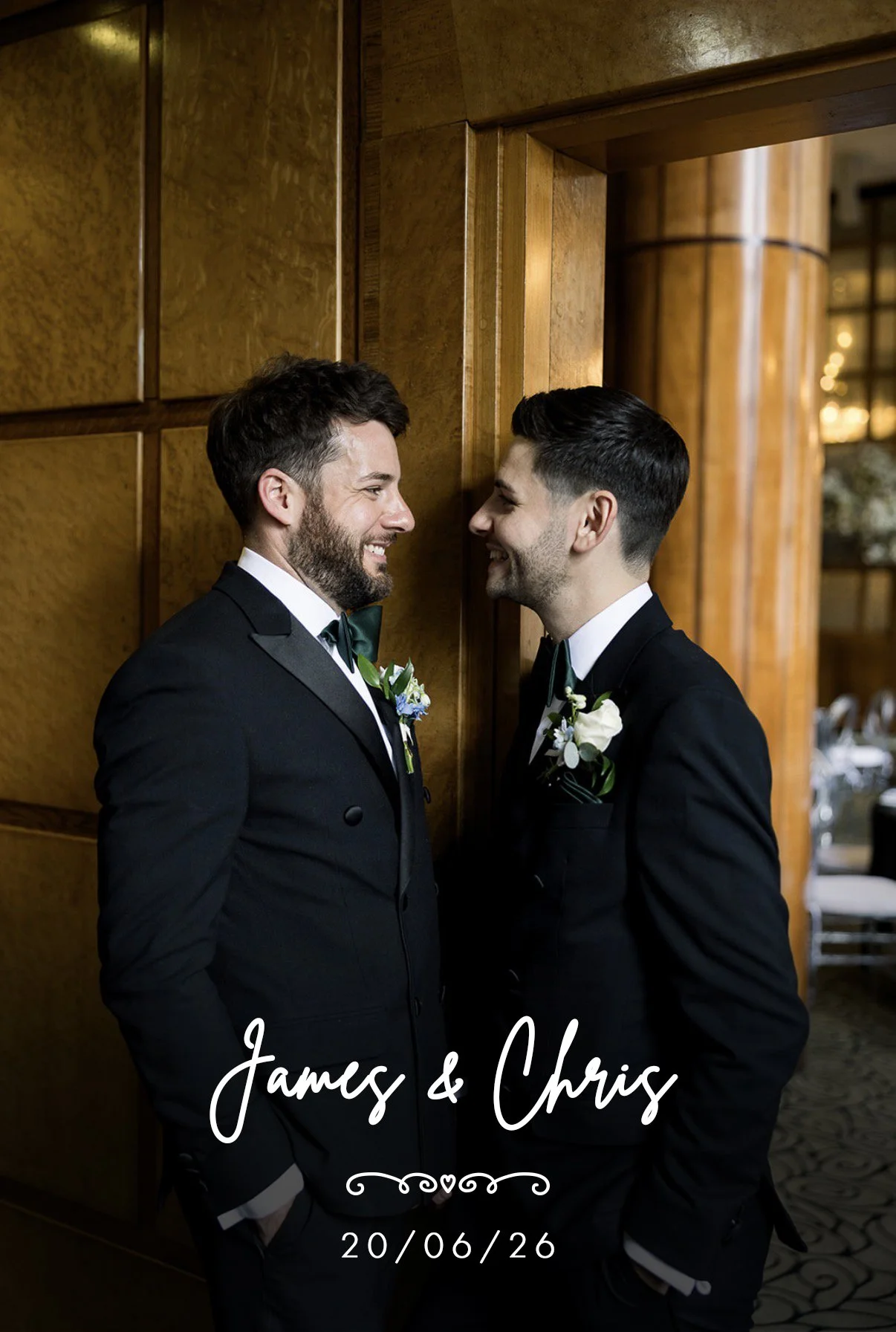 Two men in tuxedos with boutonnières smiling at each other, standing face to face in an elegant wooden interior, celebrating their wedding with the text 'James & Chris' and the date '20/06/26' overlaid.