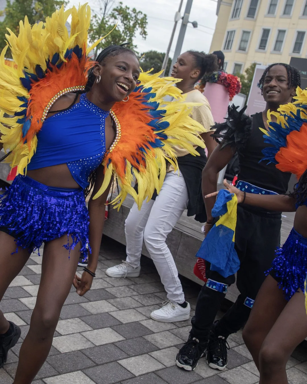 Group of people in festive, colorful costumes dancing outdoors.