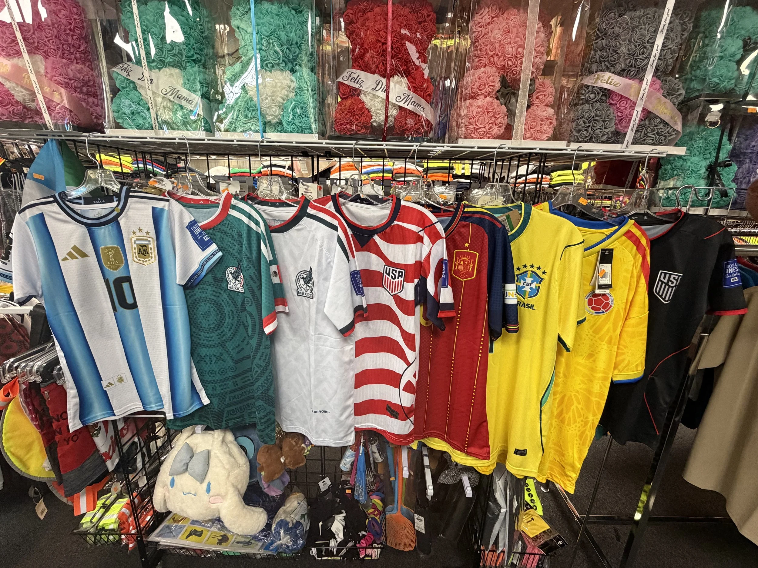 A display of soccer jerseys and gift boxes wrapped with roses inside a store.