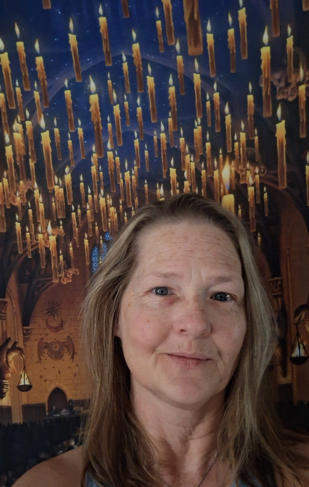 A photo of Jen Hernandez, AKA 757Scents, smiling in front of a background photo of the Great Hall from Harry Potter.