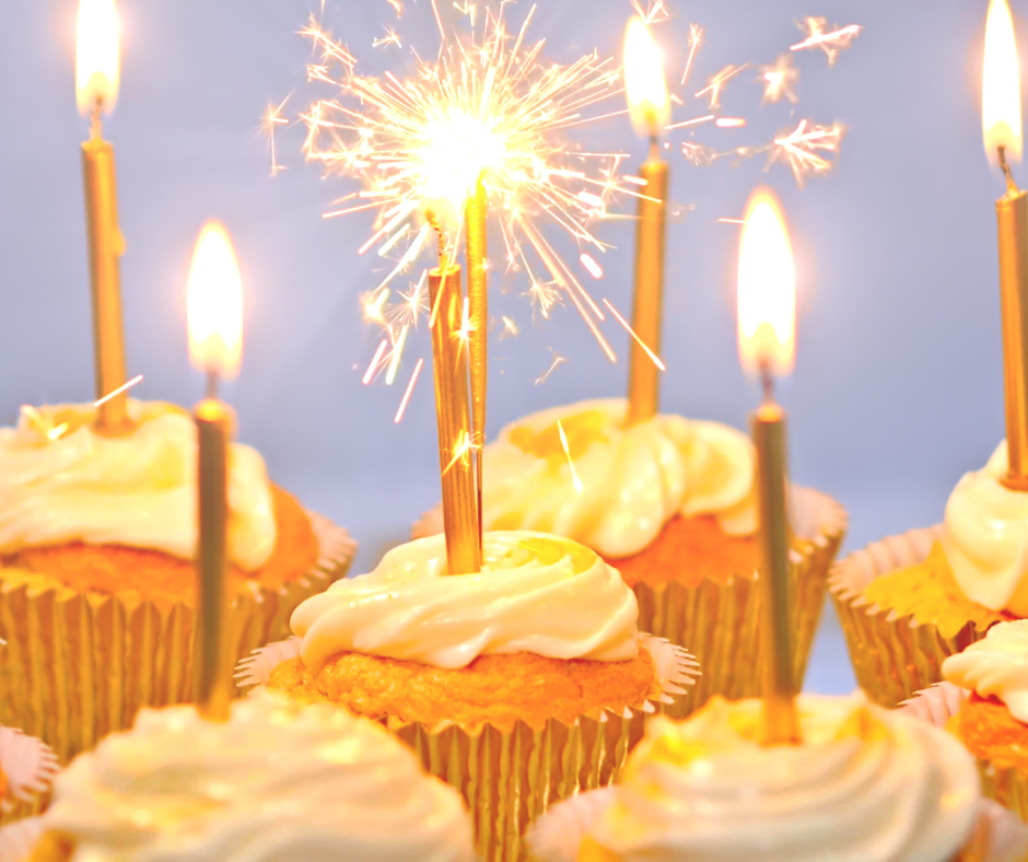 Cupcakes with lit candles and a sparkler on top, celebrating a birthday.