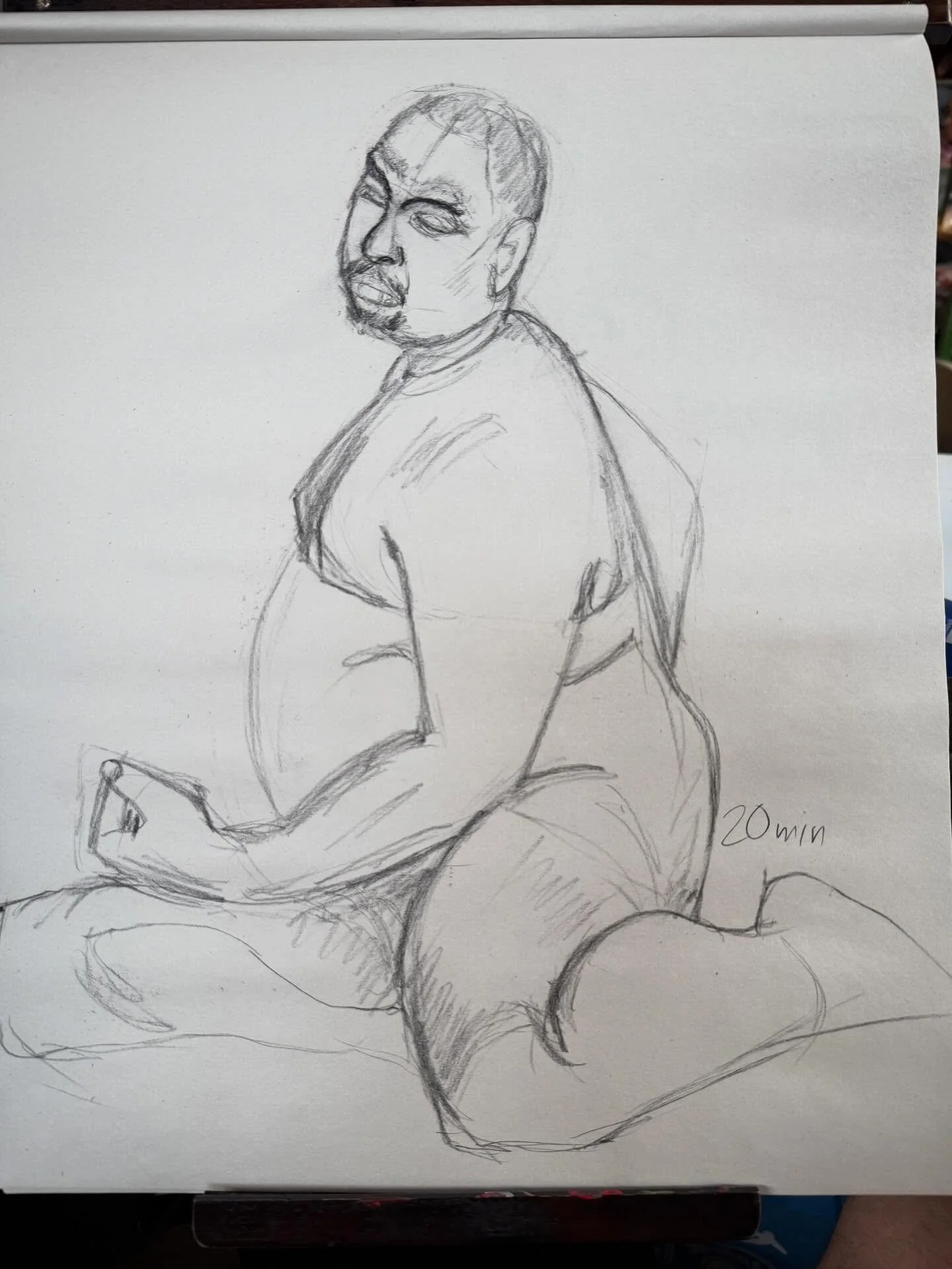 A sketch of a person sitting with their back slightly turned, looking over their shoulder while holding a phone. The person has a short haircut, and the drawing emphasizes the person's face and upper body with loose, quick lines. The note '20 min' is written in the bottom right corner.