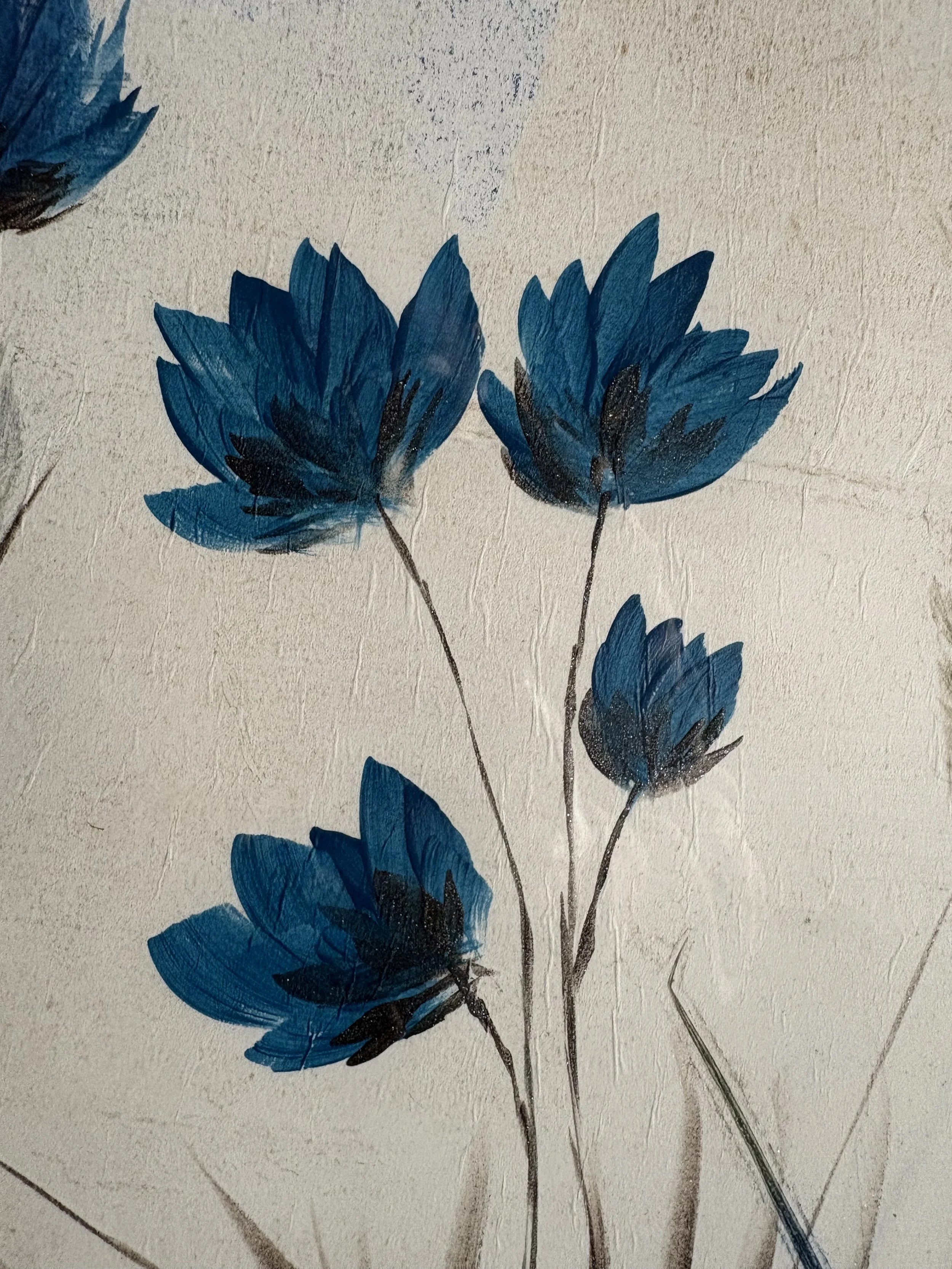 Close-up of blue flowers with dark stems painted on a textured cream-colored surface.