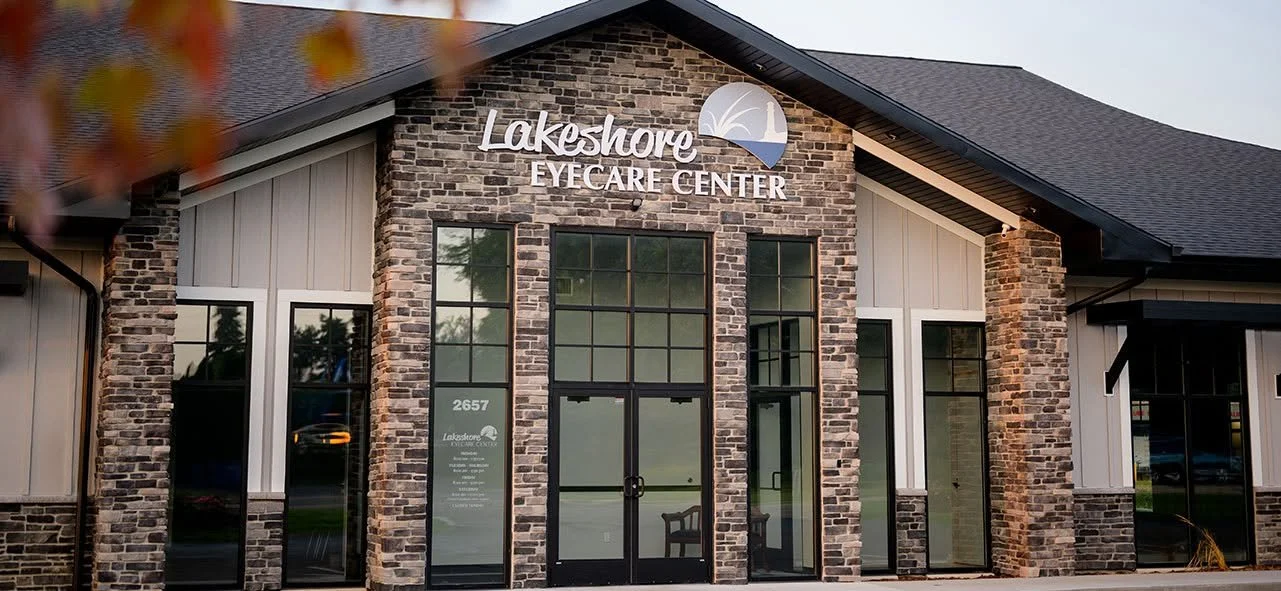 The Lakeshore Eyecare Center building with a brick and siding exterior, glass doors, and windows, and a sign with the center's name and logo on the front.