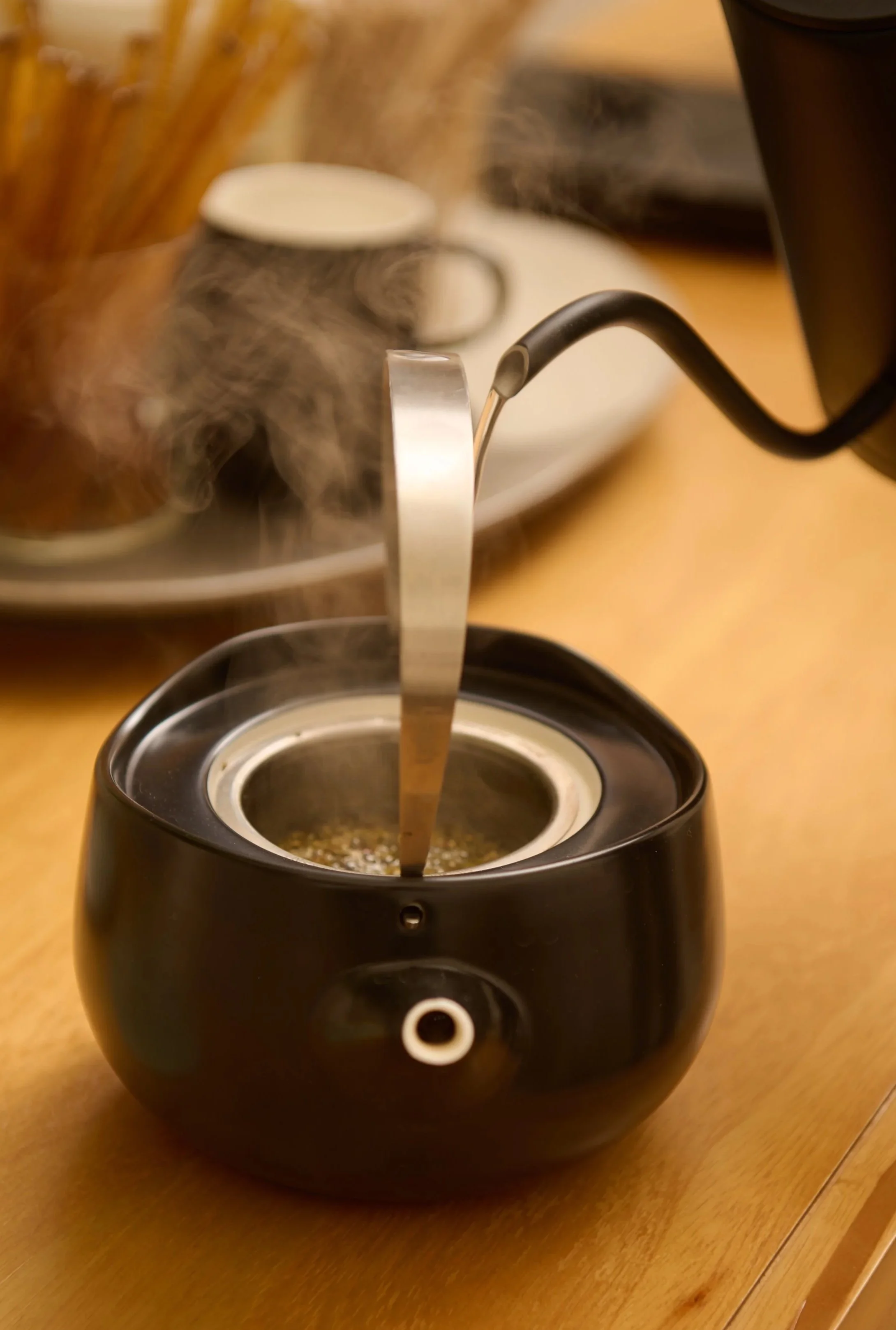 BrewingCoffeeMaker with hot steam rising as hot water flows into the coffee grounds in a coffee infuser.