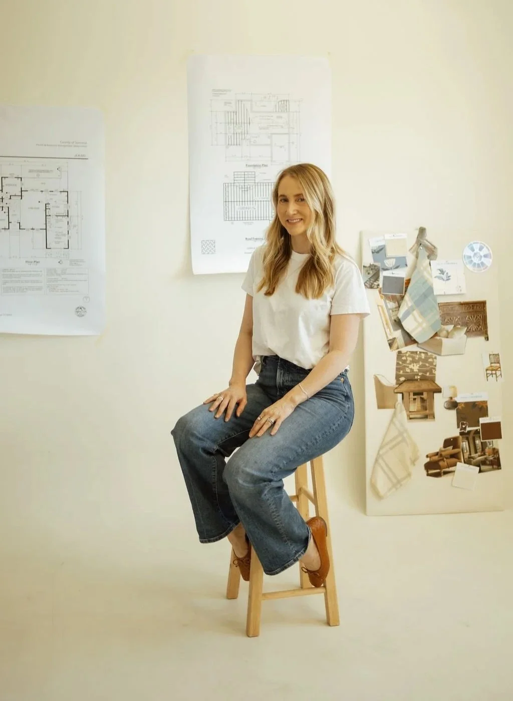 Jessica Lipsius-Arner, founder of Jessica Lipsius-Arner Interiors, surrounded by residential design plans, materials, and project inspiration.
