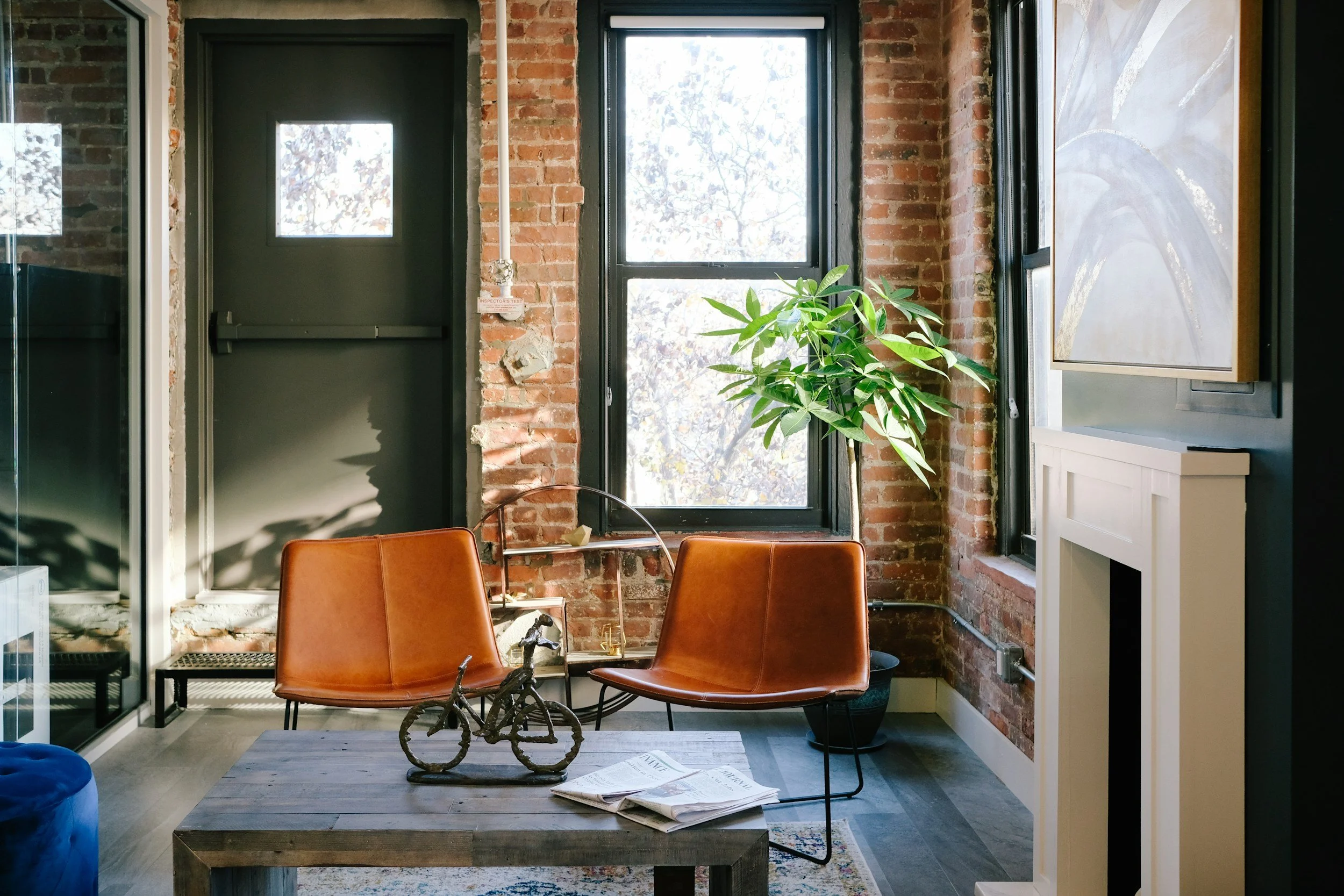 Warm, modern therapy office with brick wall, large window, and comfortable seating at Ascend Mental Health and Wellness in Montclair, CA
