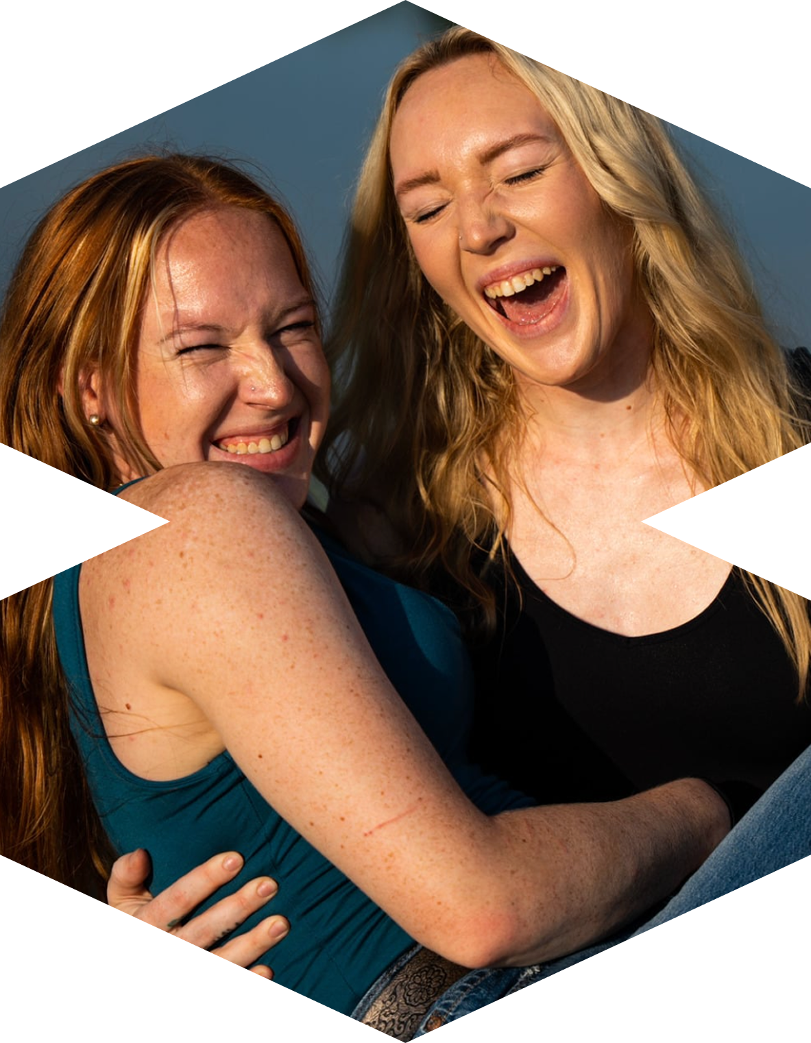 Two young women with red hair laughing outdoors