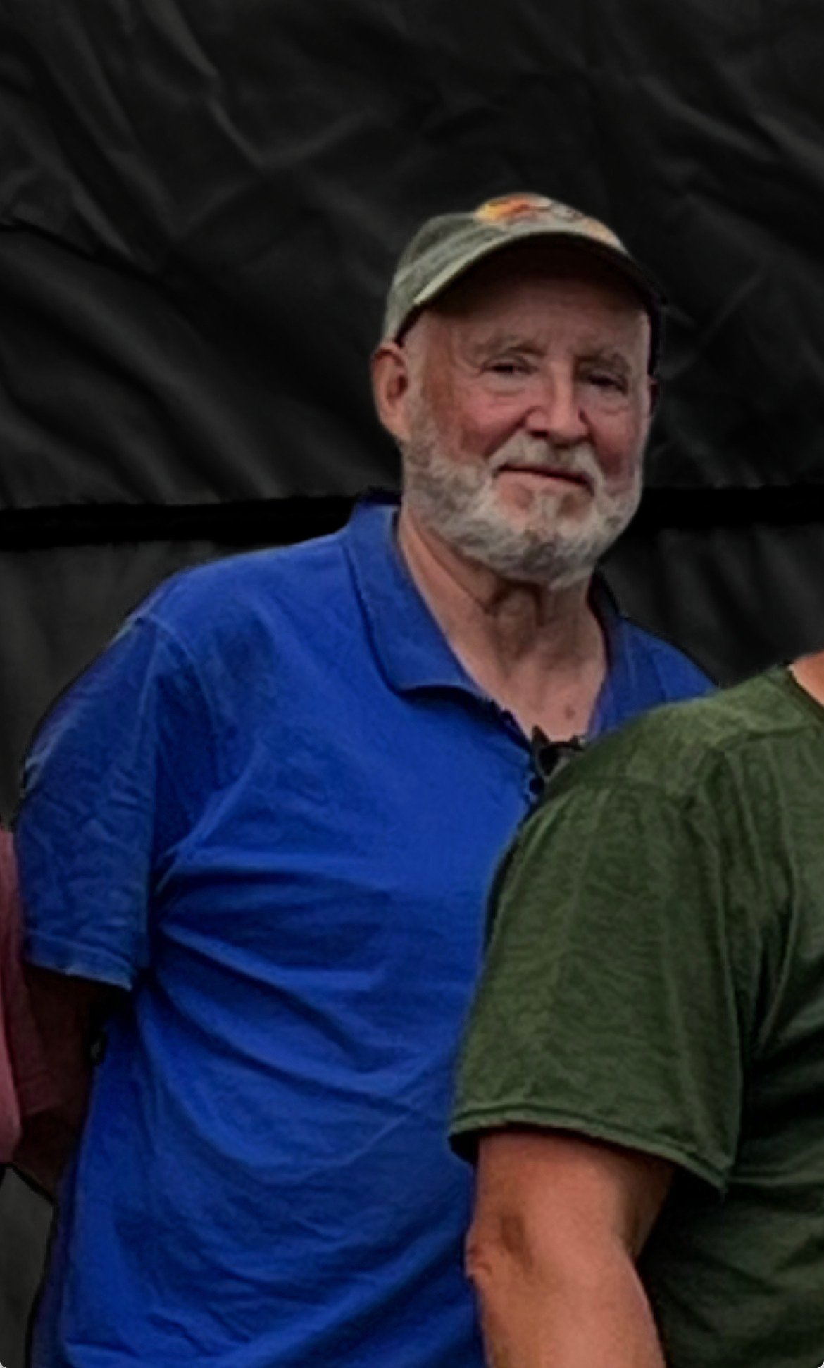 Older bearded man in a blue shirt and baseball cap