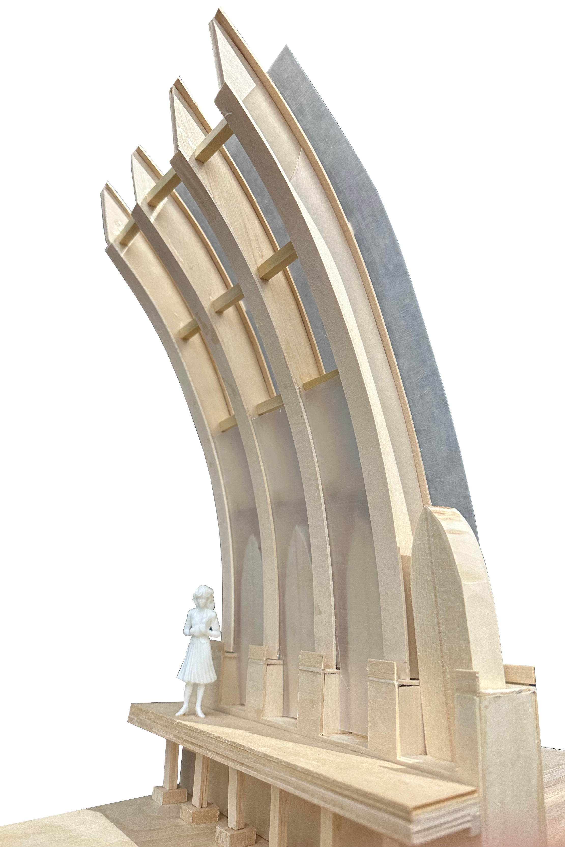 A wooden architectural model of an arched structure with a small figurine of a woman standing in front of it
