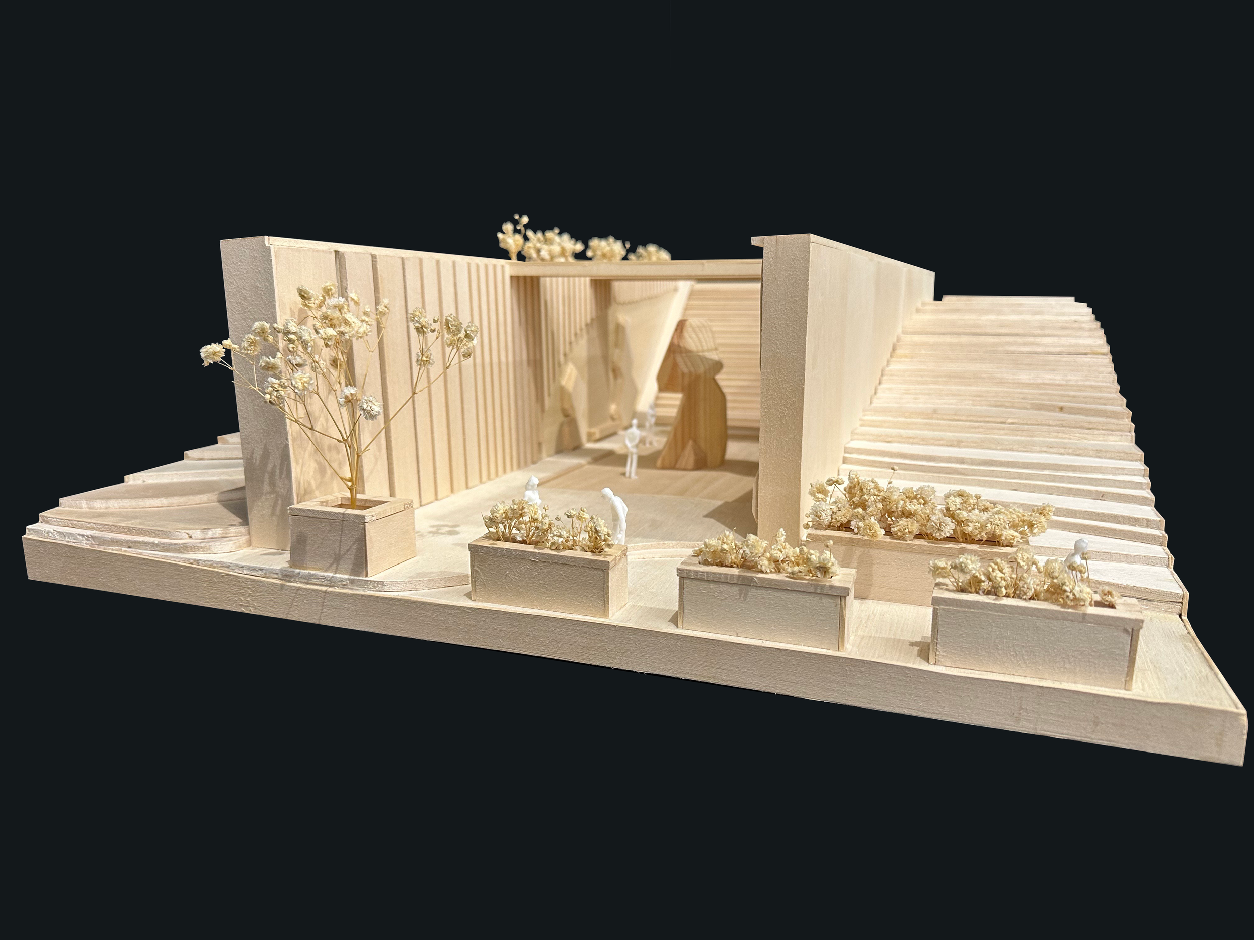 Architectural model of a modern building with stairs, trees, and miniature figures, set against a black background.