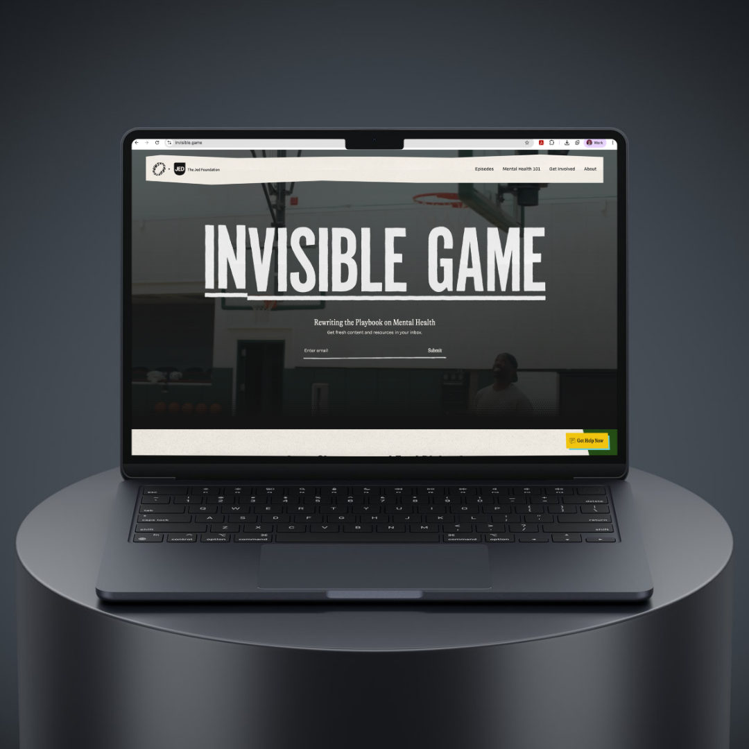 Laptop on a table displaying a website titled 'Invisible Game' with a basketball hoop in the background.