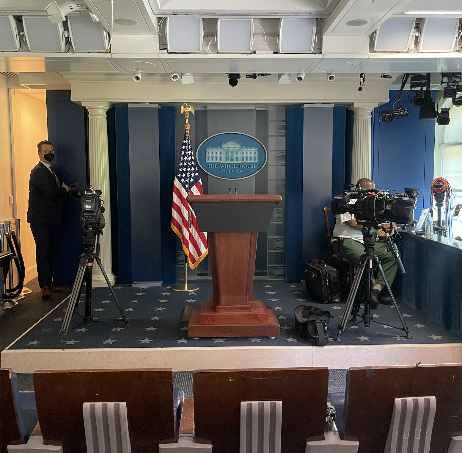 The White House press briefing room with a podium, American flag, and cameras set up for a briefing or announcement.