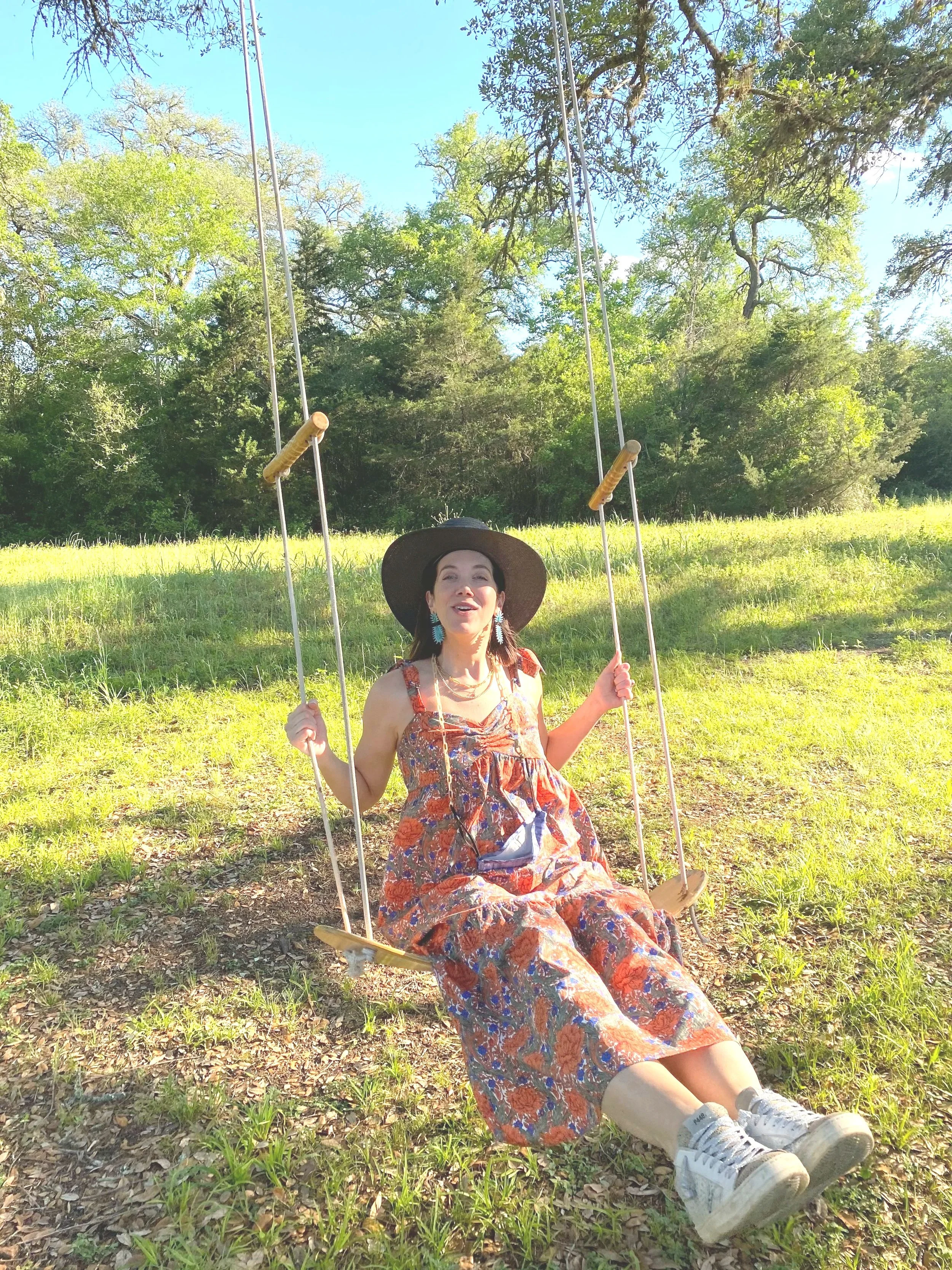 Guest relaxing on a tree swing at Oak's End Ranch, a private ranch retreat near Round Top, Texas surrounded by open fields, mature oak trees, and peaceful countryside.