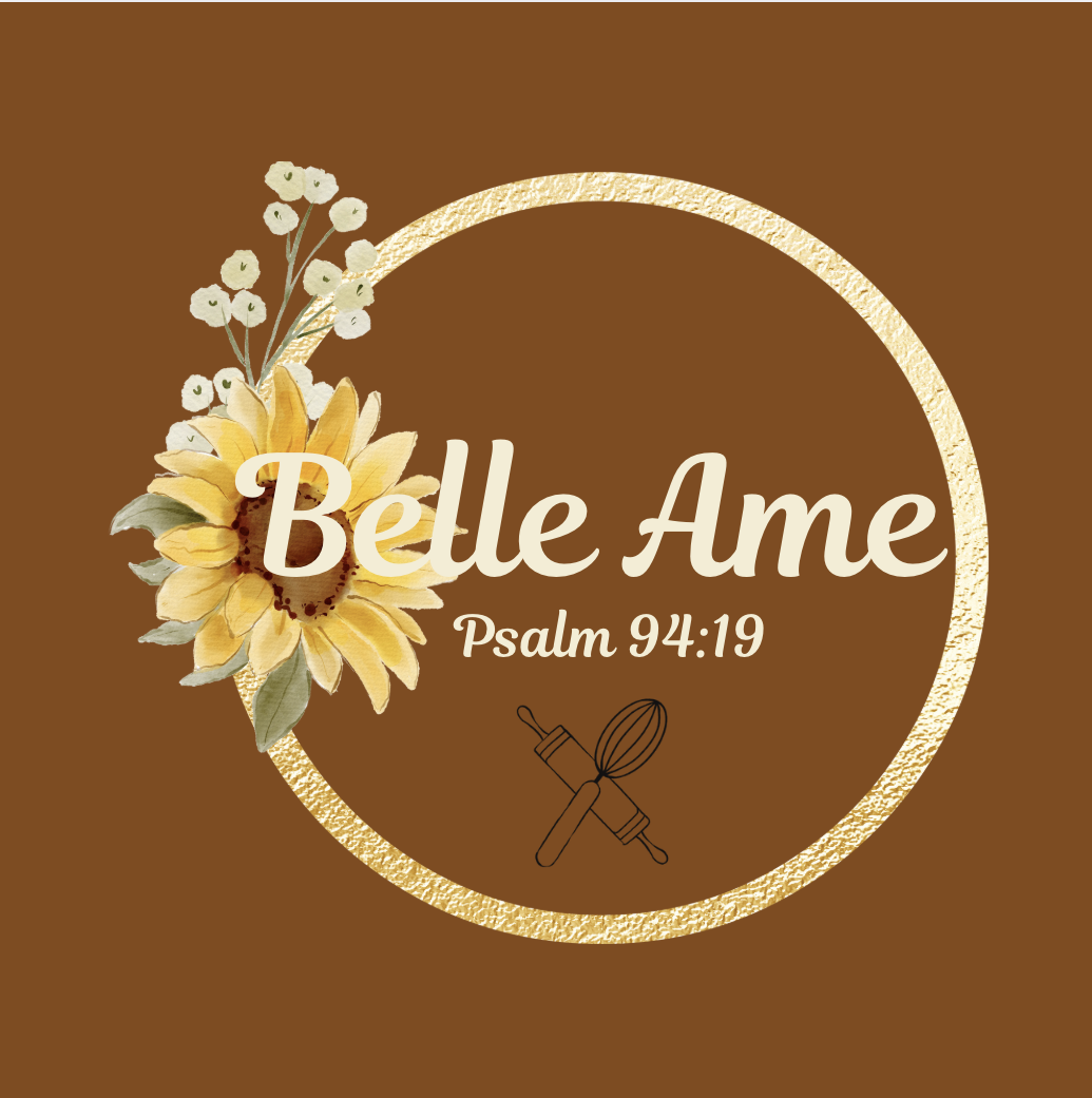 Brown background with a gold circular border, a sunflower, small white flowers, and kitchen utensils below the text. The text reads 'Belle Ame' and 'Psalm 94:19'.