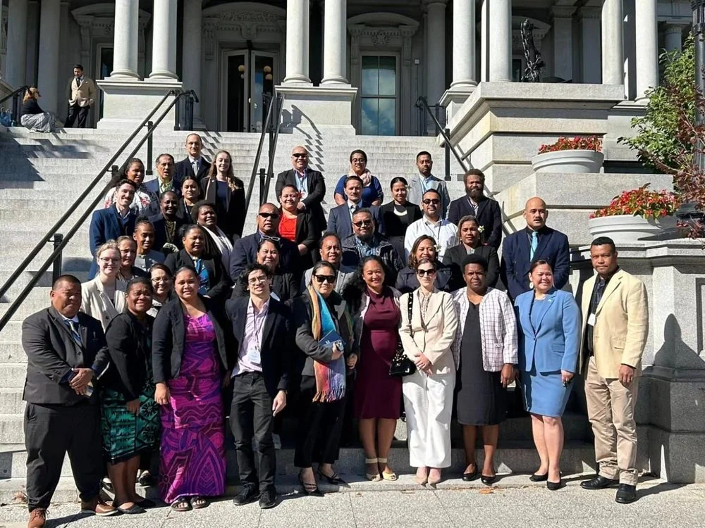 Diverse group posing on the steps of a grand neoclassical building