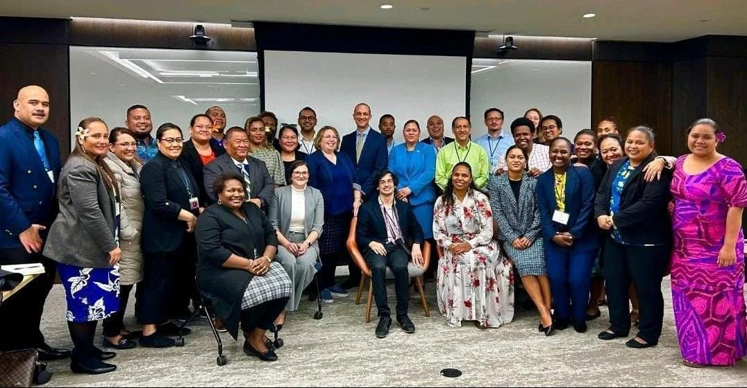 Large diverse professional group posing for a photo in a conference room