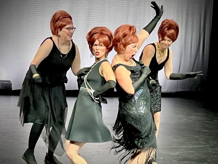Odyssey Talent Show :  Four women in vintage-inspired black dresses, gloves, and red hairstyles perform a theatrical dance onstage.