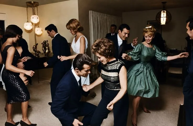 People dancing and socializing at a party with vintage decor.