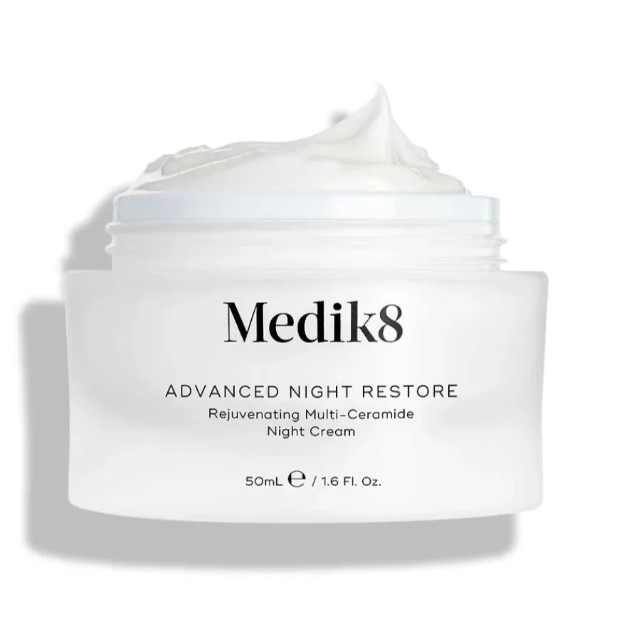 A white jar of Medik8 Advanced Night Restore Rejuvenating Multi-Ceramide Night Cream with a swirl of cream on top, set against a plain white background.