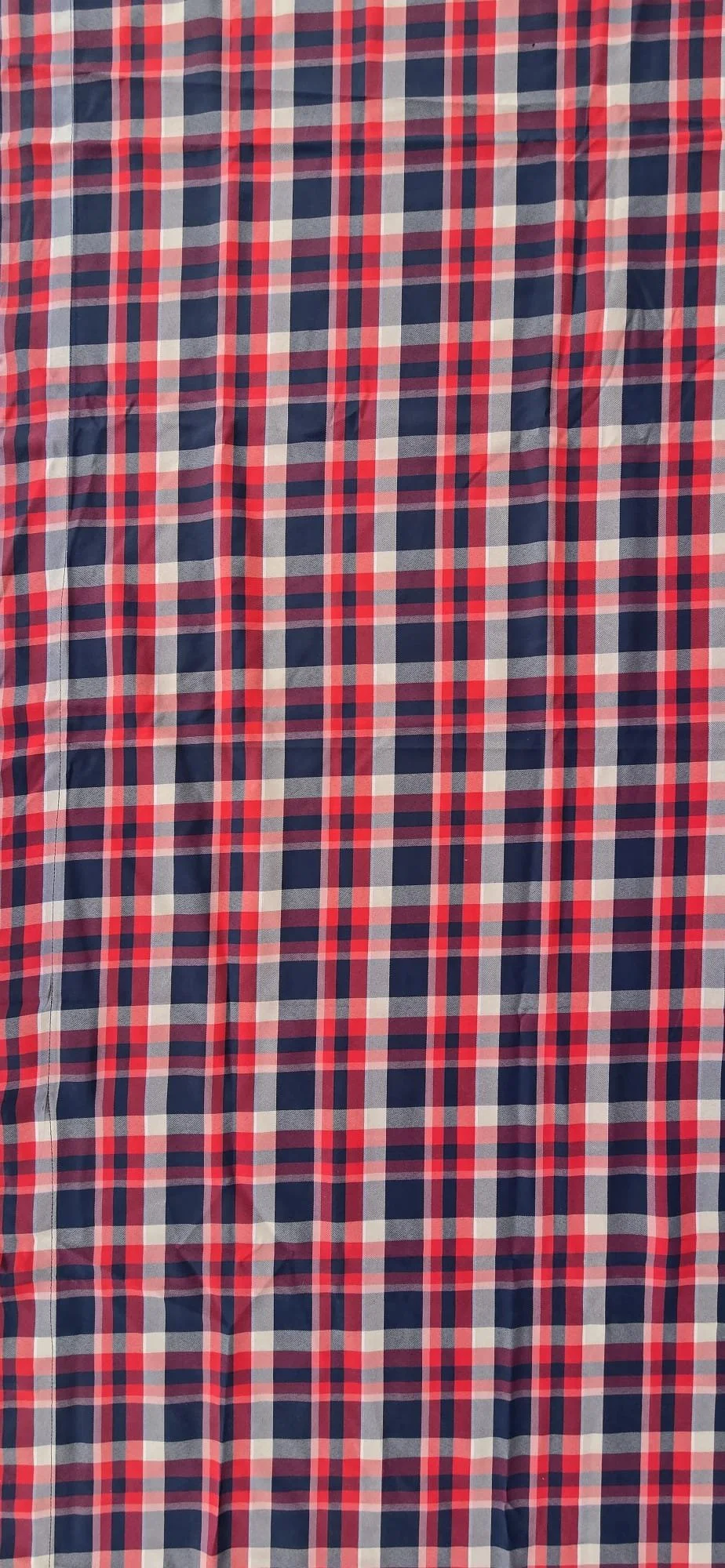 Close-up of red, white, and navy blue plaid fabric with a gingham pattern.