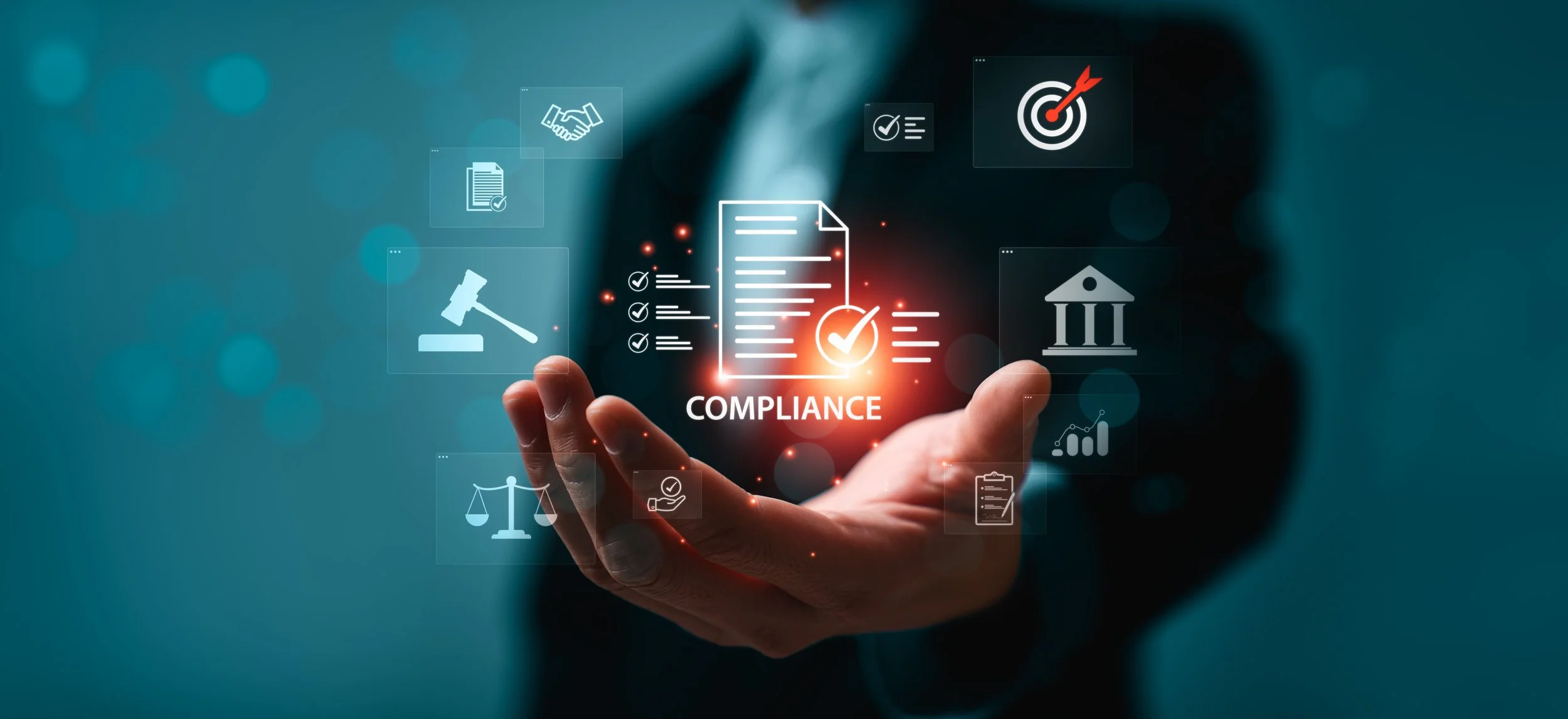 A hand holding a digital graphic with icons representing compliance, including a checkmark, a gavel, a handshake, a document, a courthouse, and a target with an arrow, with the word 'COMPLIANCE' in the center.