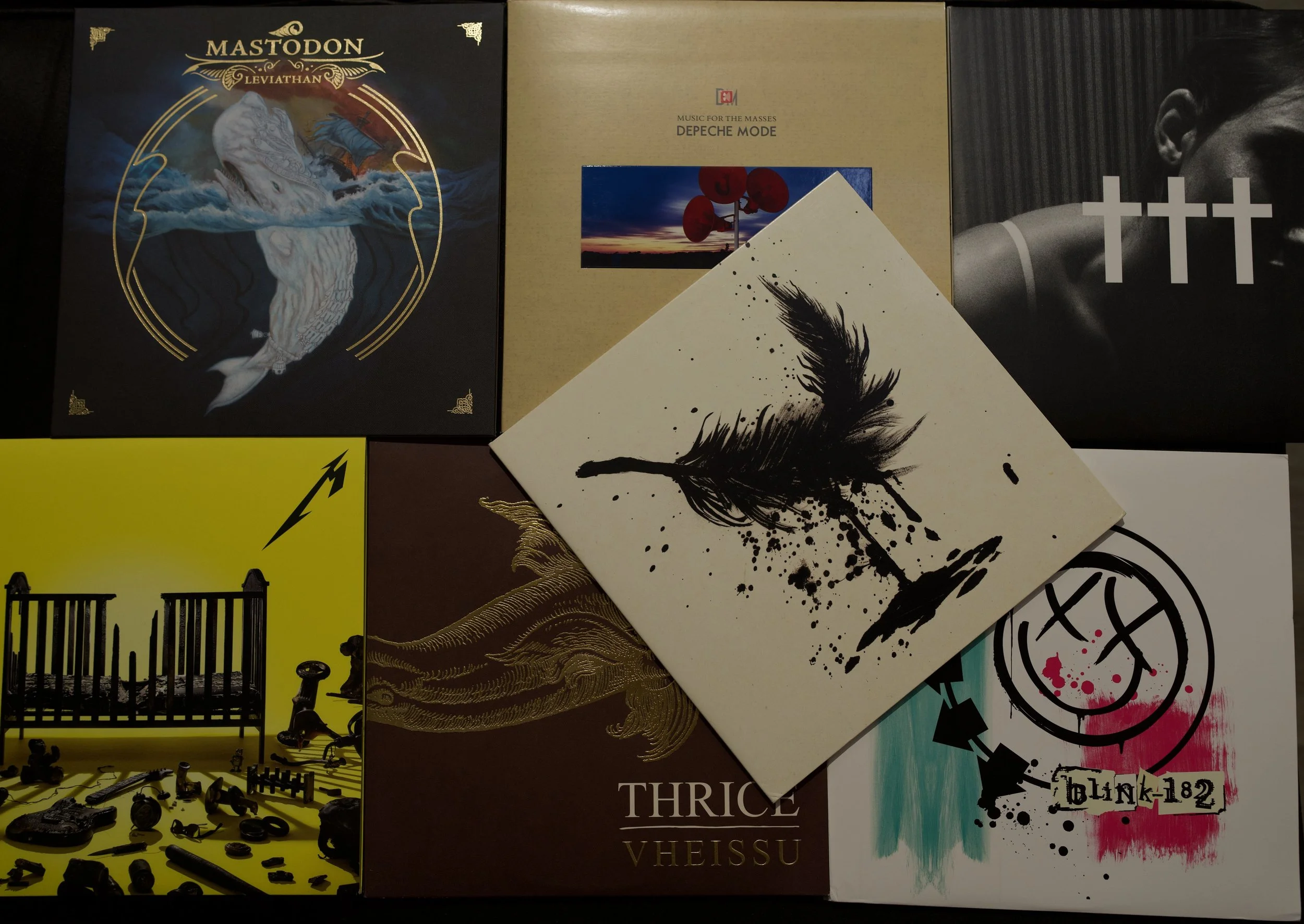 A collection of various vinyl record album covers, including Mastodon Leviathan, Depeche Mode Music for the Masses, and others with artistic and colorful designs.