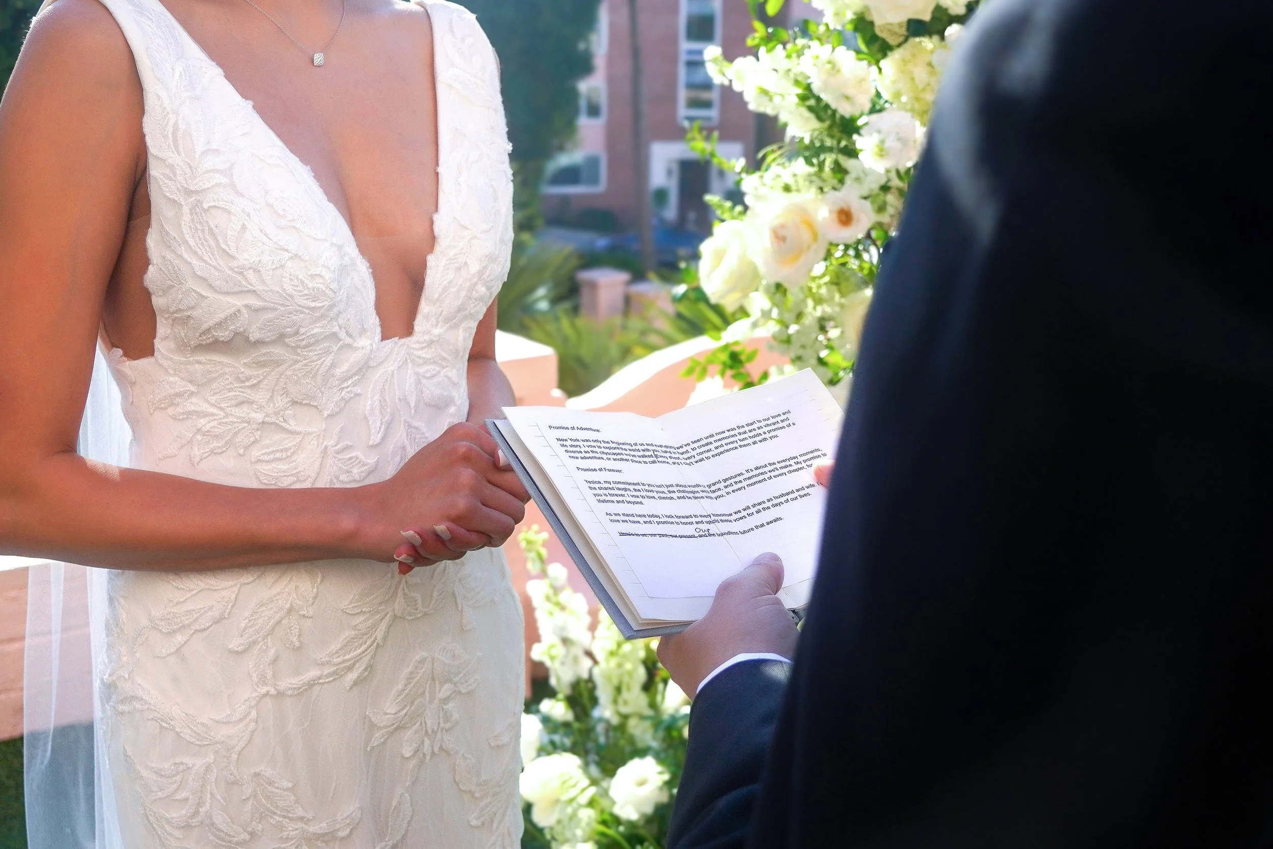 Bride Yesica Lepe listening to wedding vows from groom Joshua Cohen during their outdoor ceremony at La Valencia Hotel in La Jolla, San Diego.