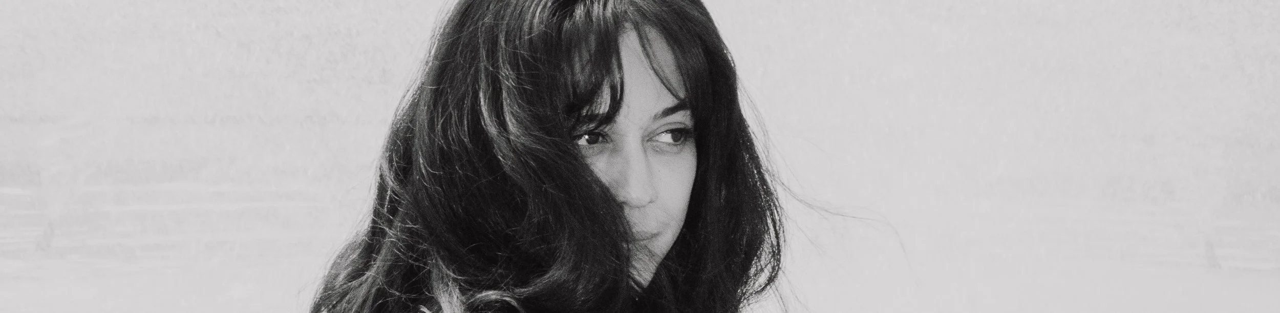 Close up black and white portrait of a woman with dark hair and dark eyes