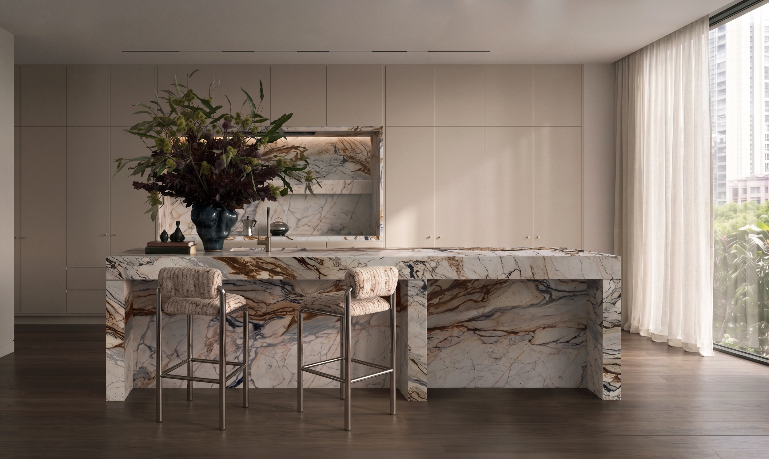Modern kitchen with a marble island, a large floral arrangement in a dark blue vase, built-in white cabinets, and floor-to-ceiling windows with white curtains.