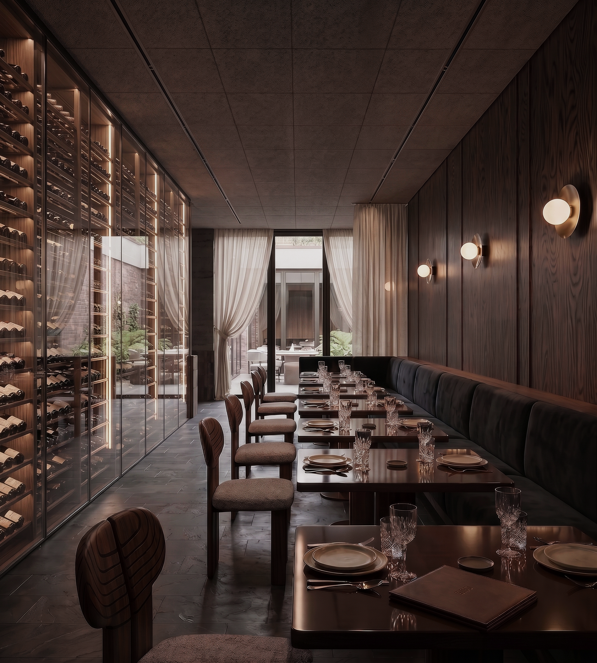 Elegant dining area with a long black leather banquette, wooden table set with plates and crystal glasses, and a wine display on the left wall