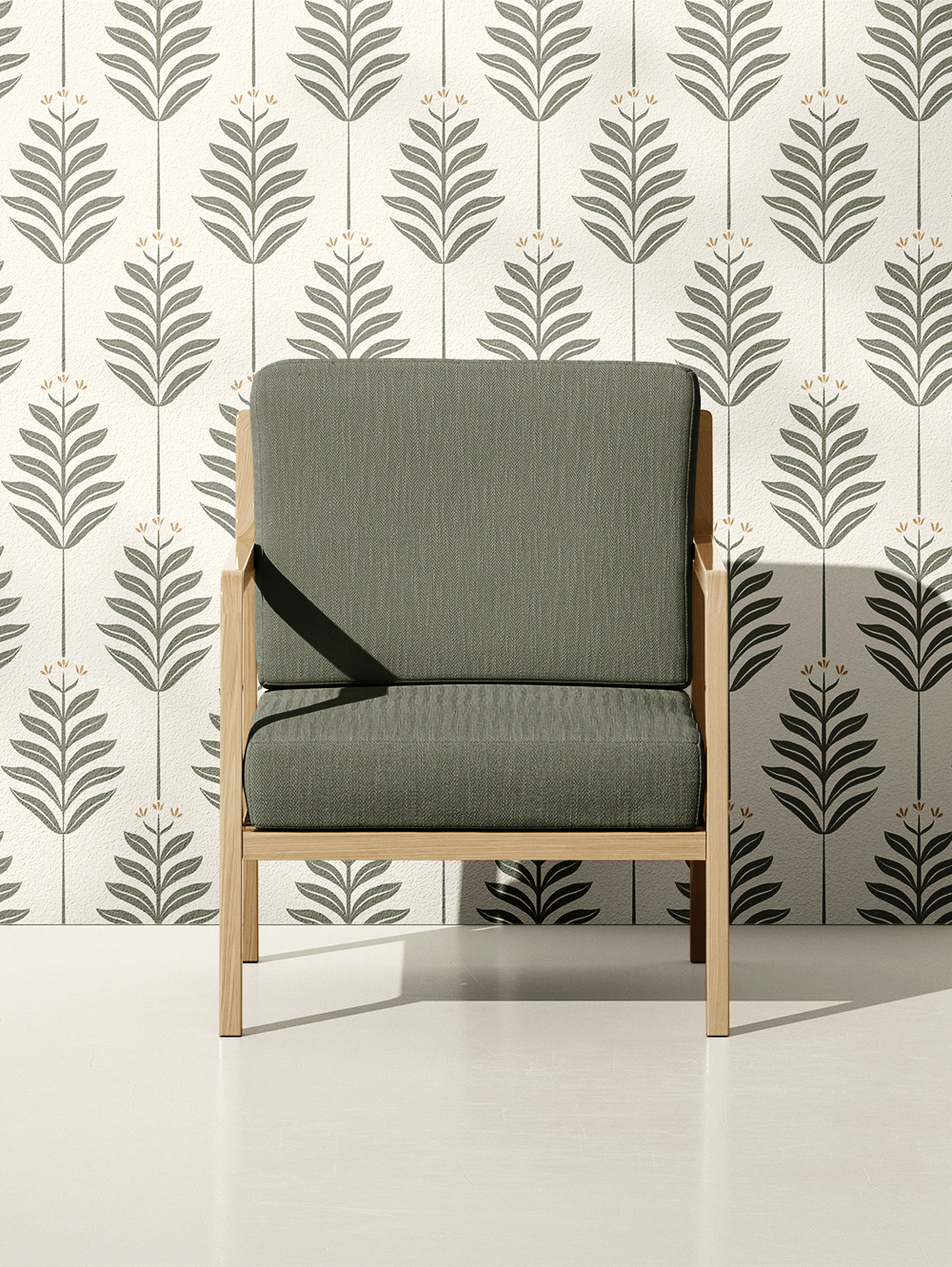 A mid-century modern chair with green upholstered cushions and light wood frame in front of a wallpapered wall with a repeating botanical pattern.