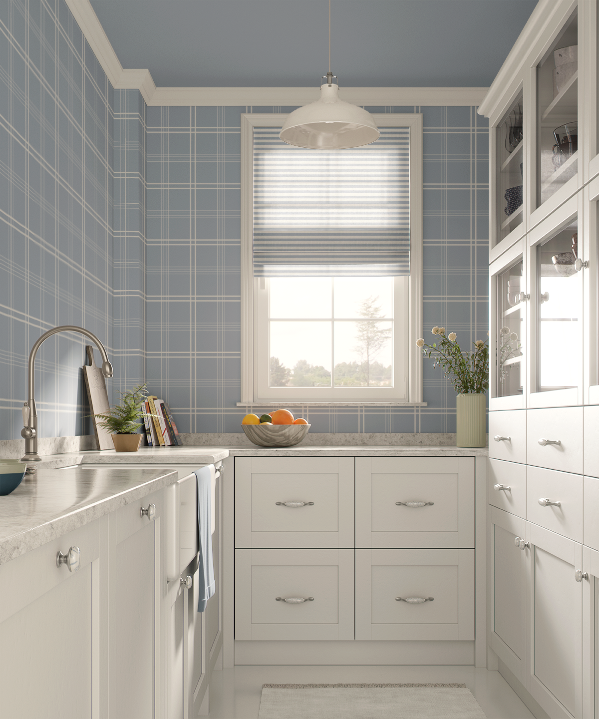 A bright kitchen with white cabinets, a window with a striped roller blind, a gray countertop with fruits in a bowl, potted plants, and a chandelier.