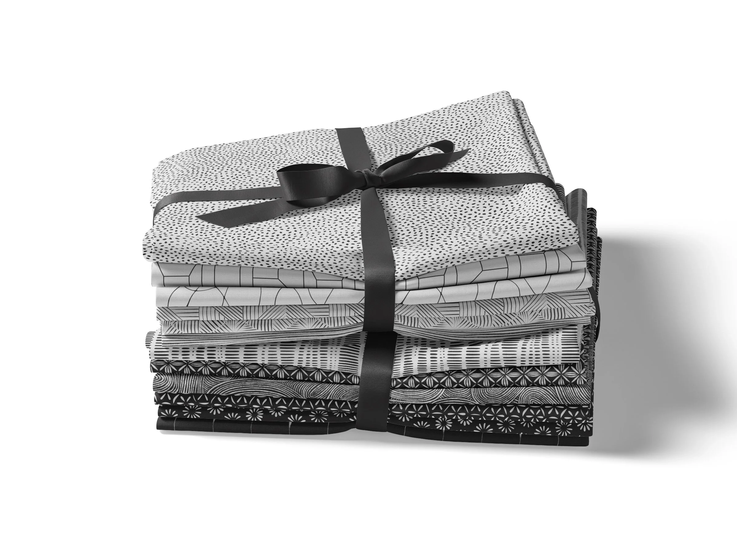 A stack of folded black-and-white patterned fabric or paper, tied with a black ribbon.