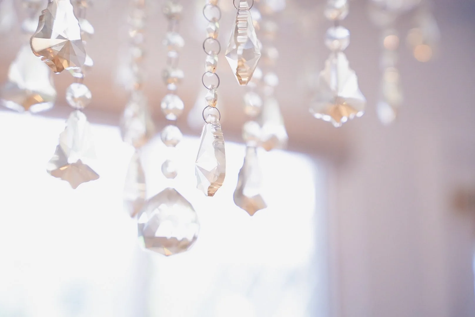 Close-up of a chandelier with hanging crystal pendants reflecting light.