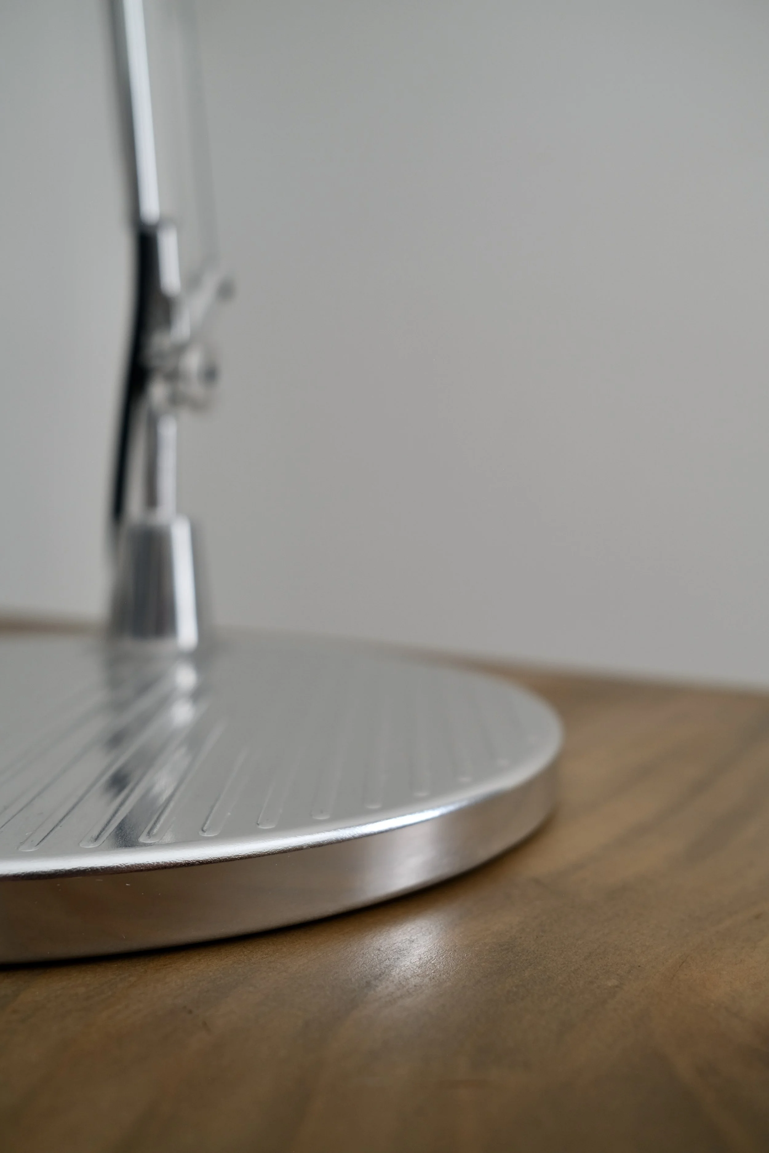 Detailed view featuring a Tolomeo table lamp chrome base from Artemide