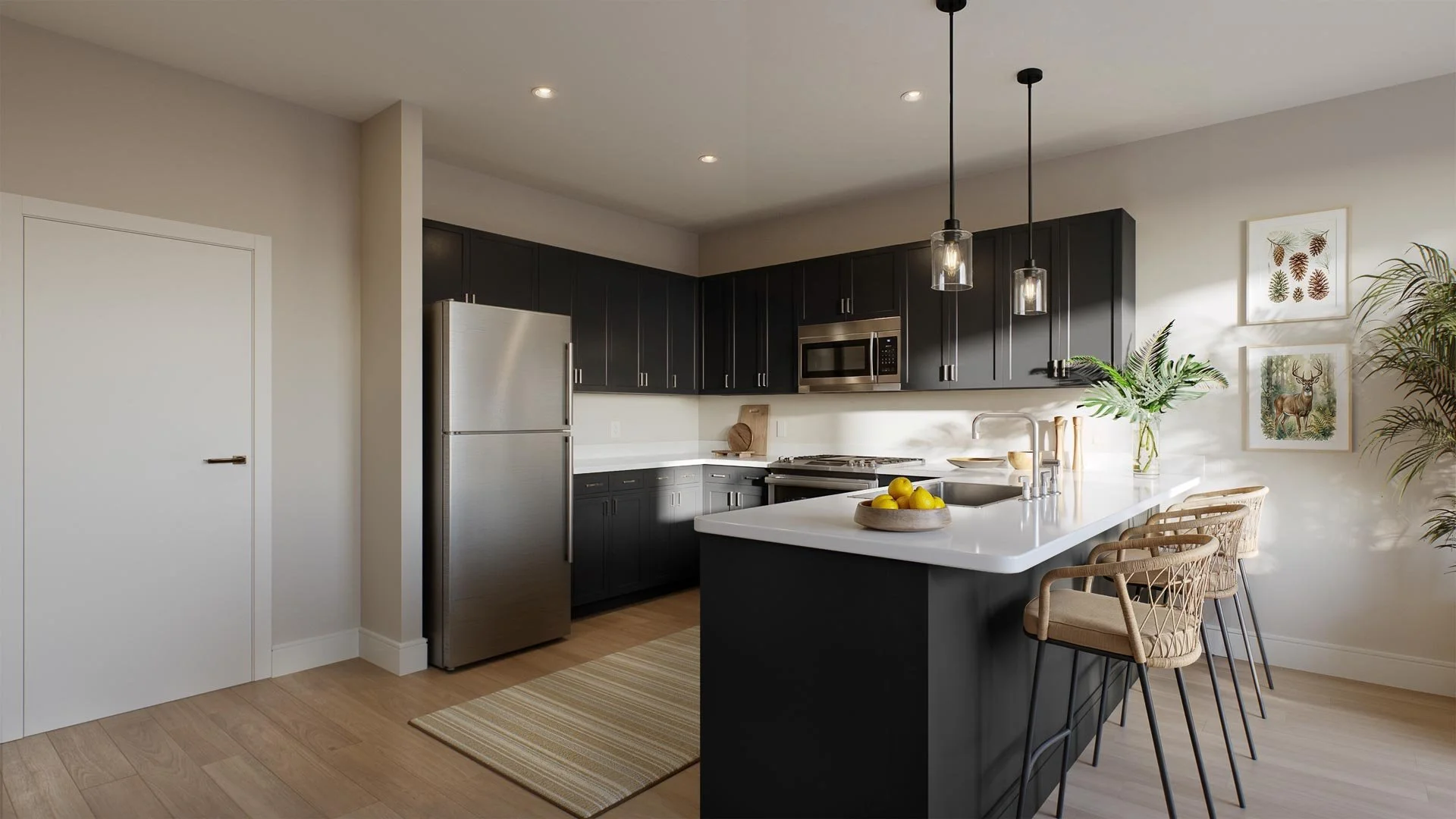 Modern kitchen with black cabinets, stainless steel appliances, white countertop island with a bowl of lemons, pendant lights, and wall art including a deer and nature prints, complemented by woven chairs at Mill + Miss Apartments in Grand Rapids, MN