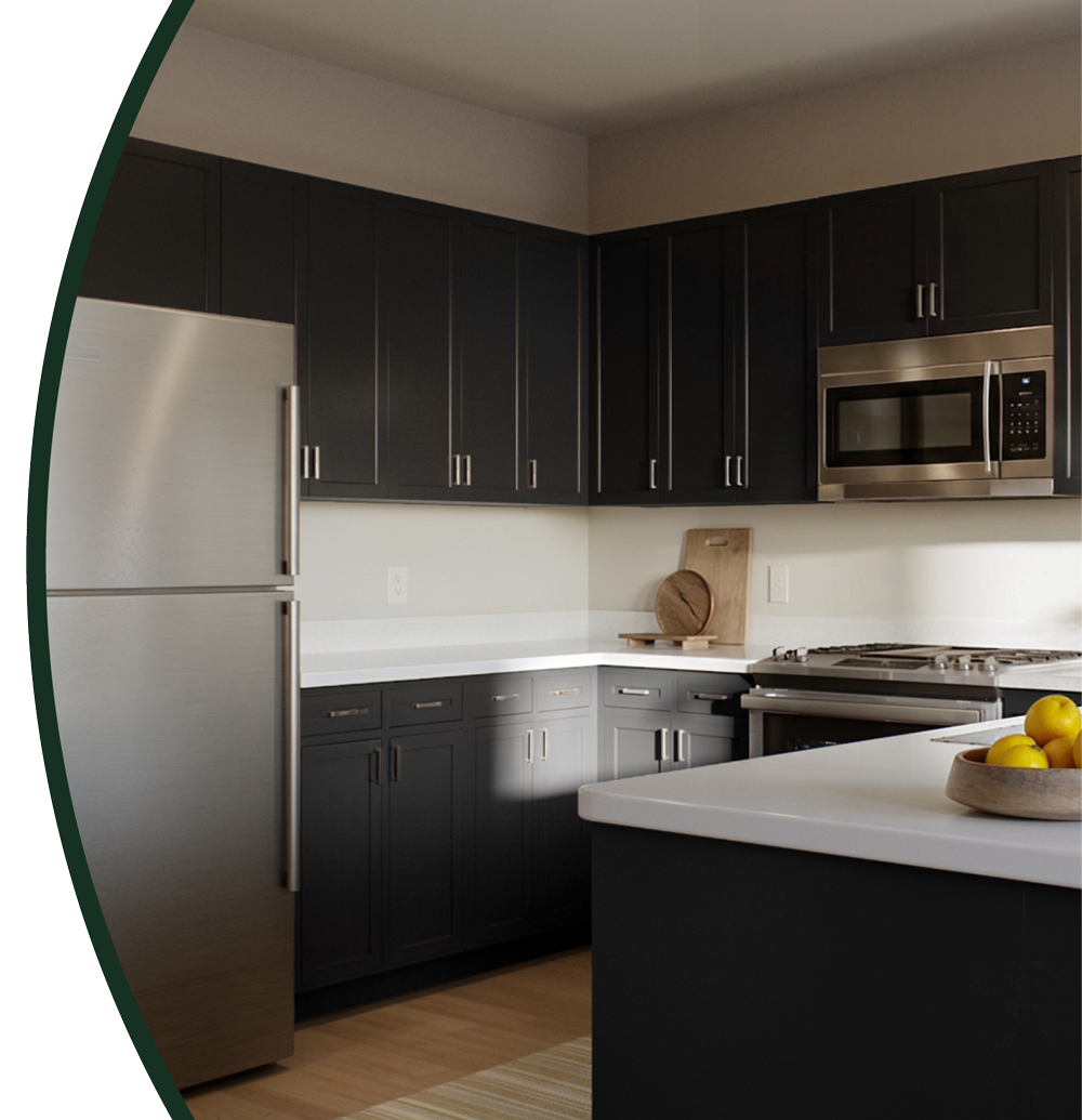 Modern kitchen with dark cabinets, stainless steel refrigerator, microwave, and gas stove, and a white countertop with a wooden bowl of yellow lemons at Mill + Miss Apartments in Grand Rapids, MN.
