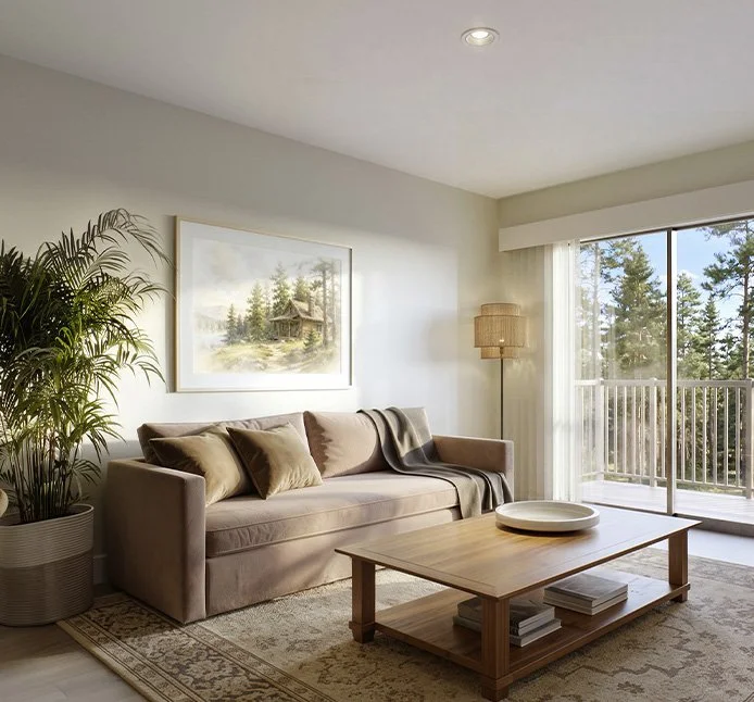 Living room with beige sofa, throw pillows, a framed landscape painting, a potted plant, a wooden coffee table with books and a decorative tray, a floor lamp, and sliding glass doors leading to a balcony with trees outside at Mill + Miss Apartments.