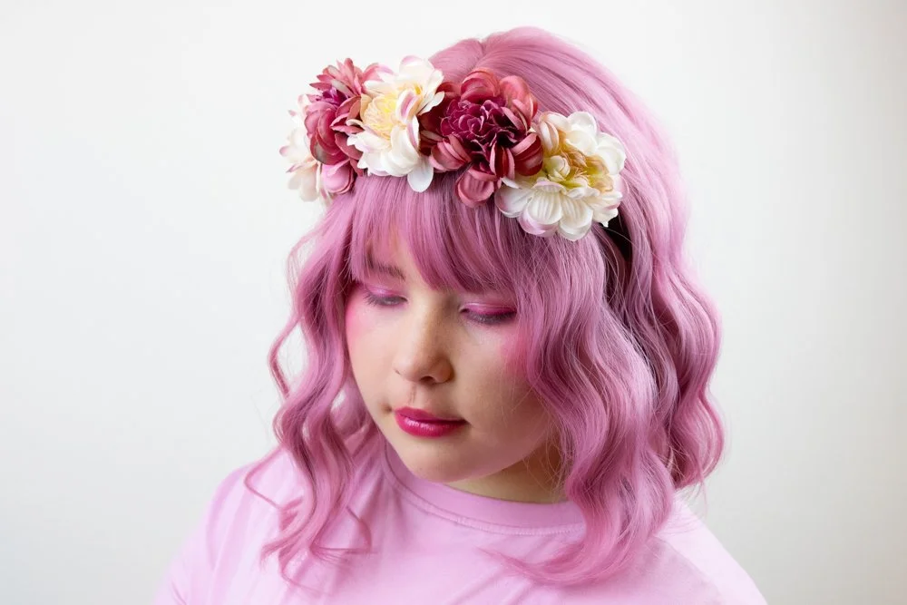 portrait of girl with pink hair wearing flower crown