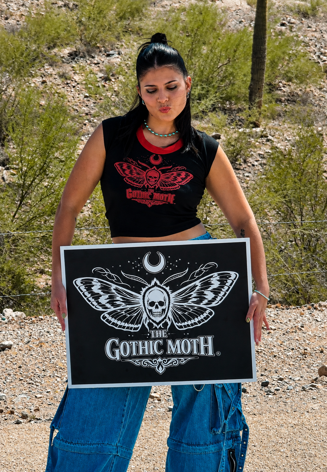 Julia Holding the Gothic Moth Sign and wearing Baby Crop.png