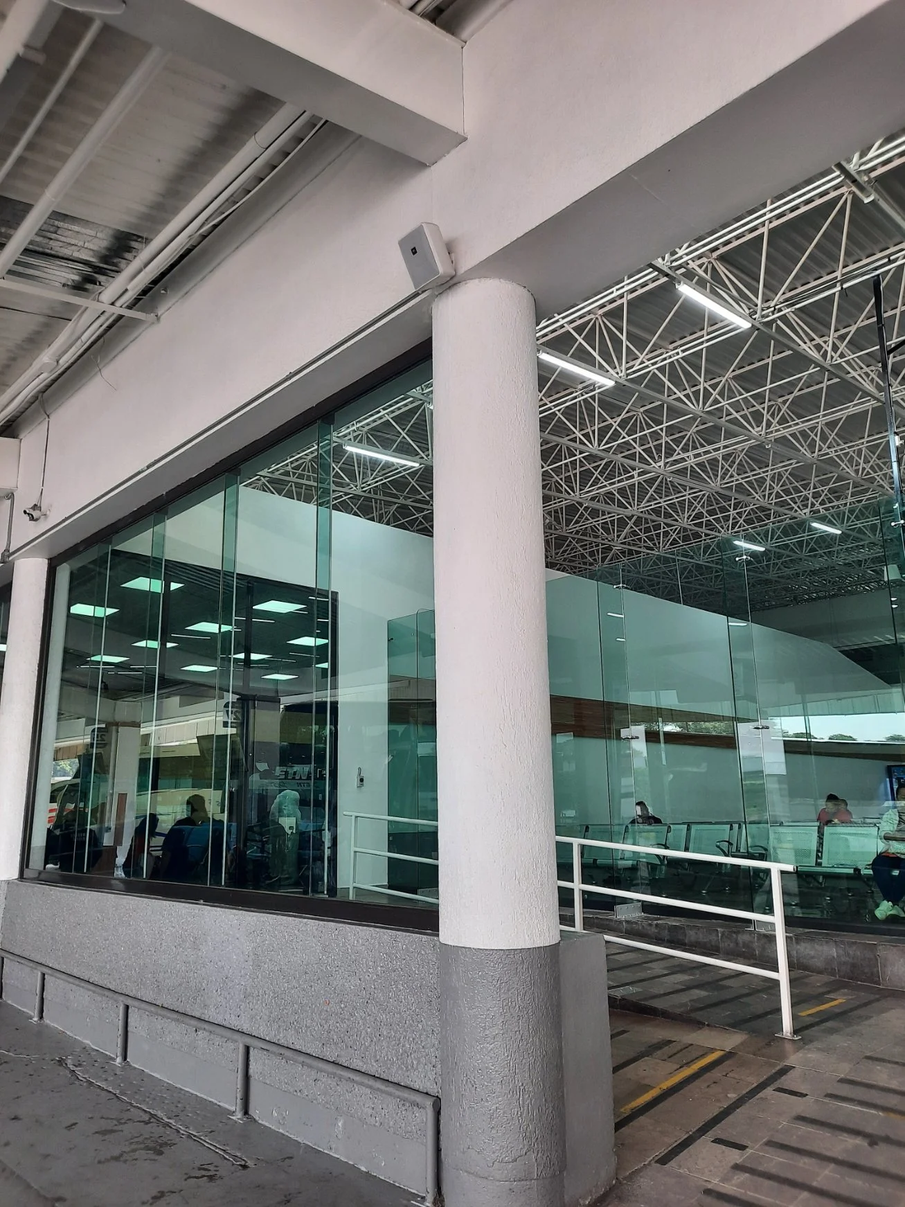 Interior de una terminal de transporte con ventanas de vidrio y escaleras eléctricas