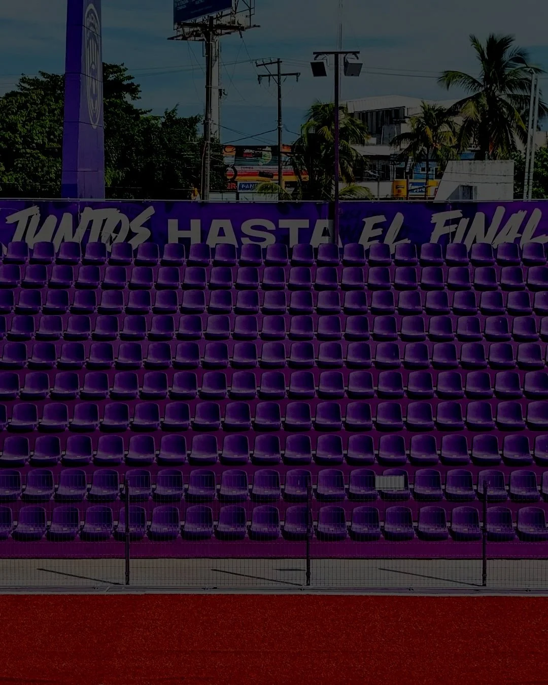 Gradas de asientos morados en un estadio con la frase 'Todos hasta el final' escrita en la esquina superior.