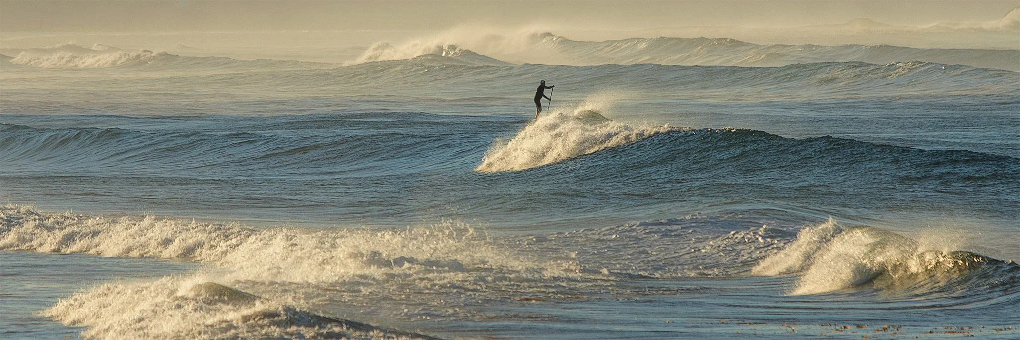 Lone paddle boarder in big surf