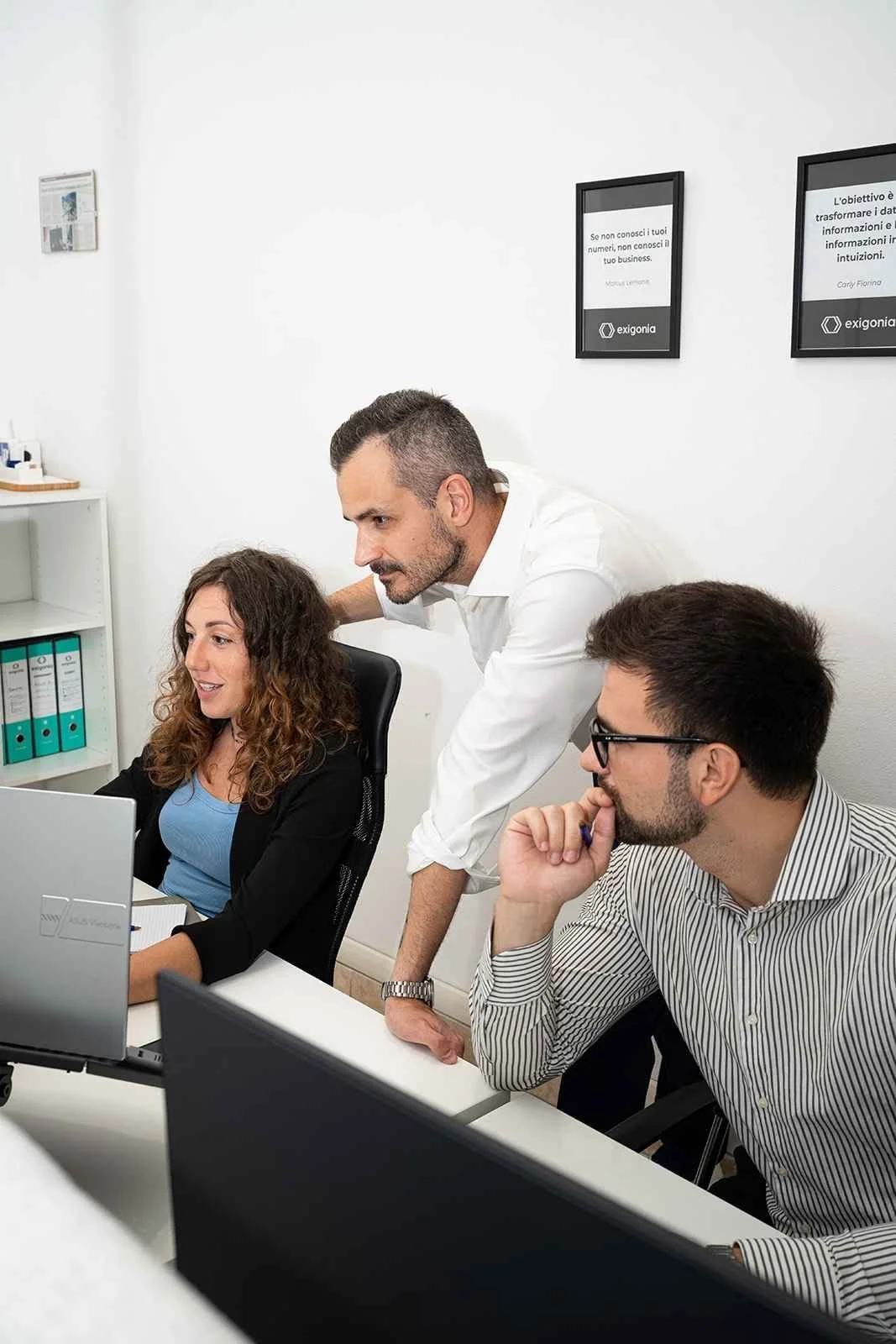 Federico Noferi e i controller analizzano un report aziendale al pc in ufficio