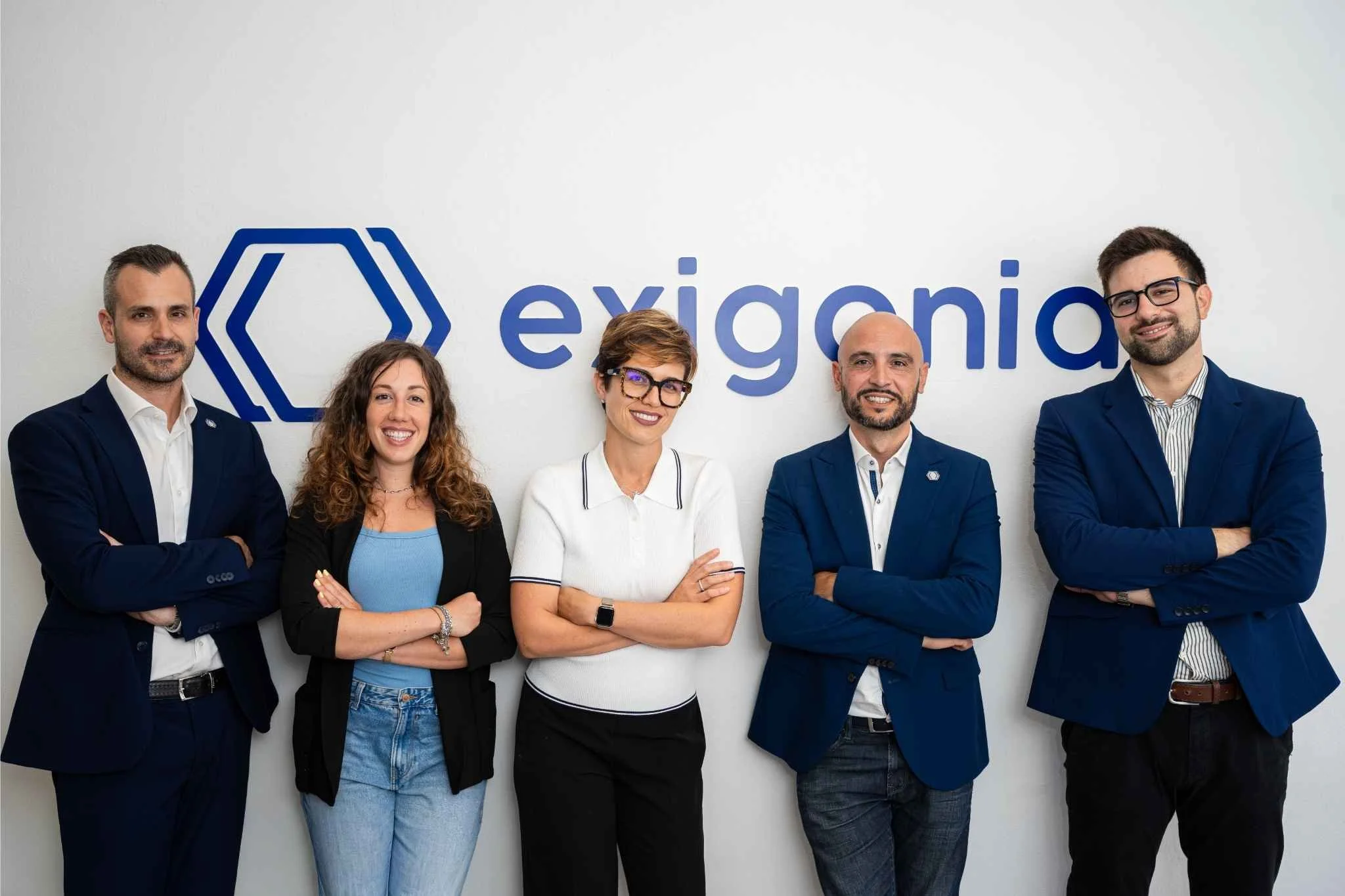 Il team di Exigonia davanti al logo exigonia.