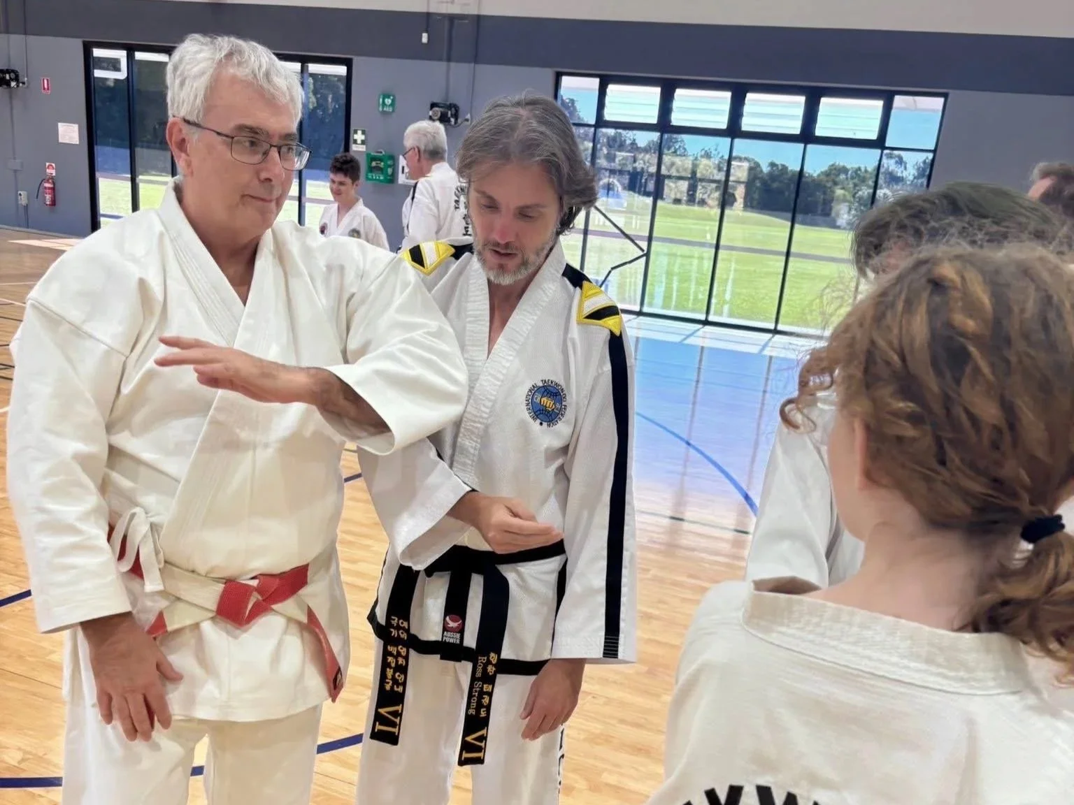 Ross Cameron coaching an instructor during a martial arts seminar at a host club.