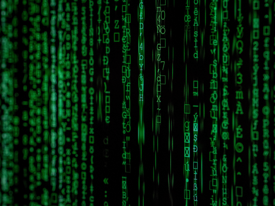 Green digital code cascading down a black background, resembling computer matrix code.