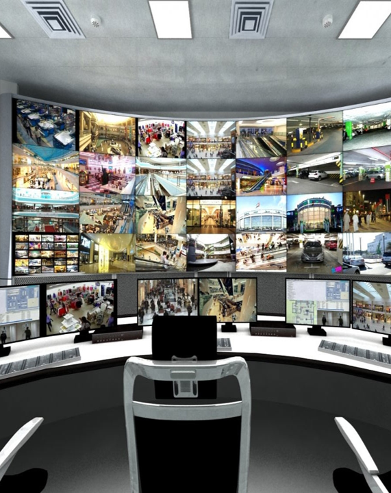Control room with multiple monitors displaying surveillance footage and security feeds.