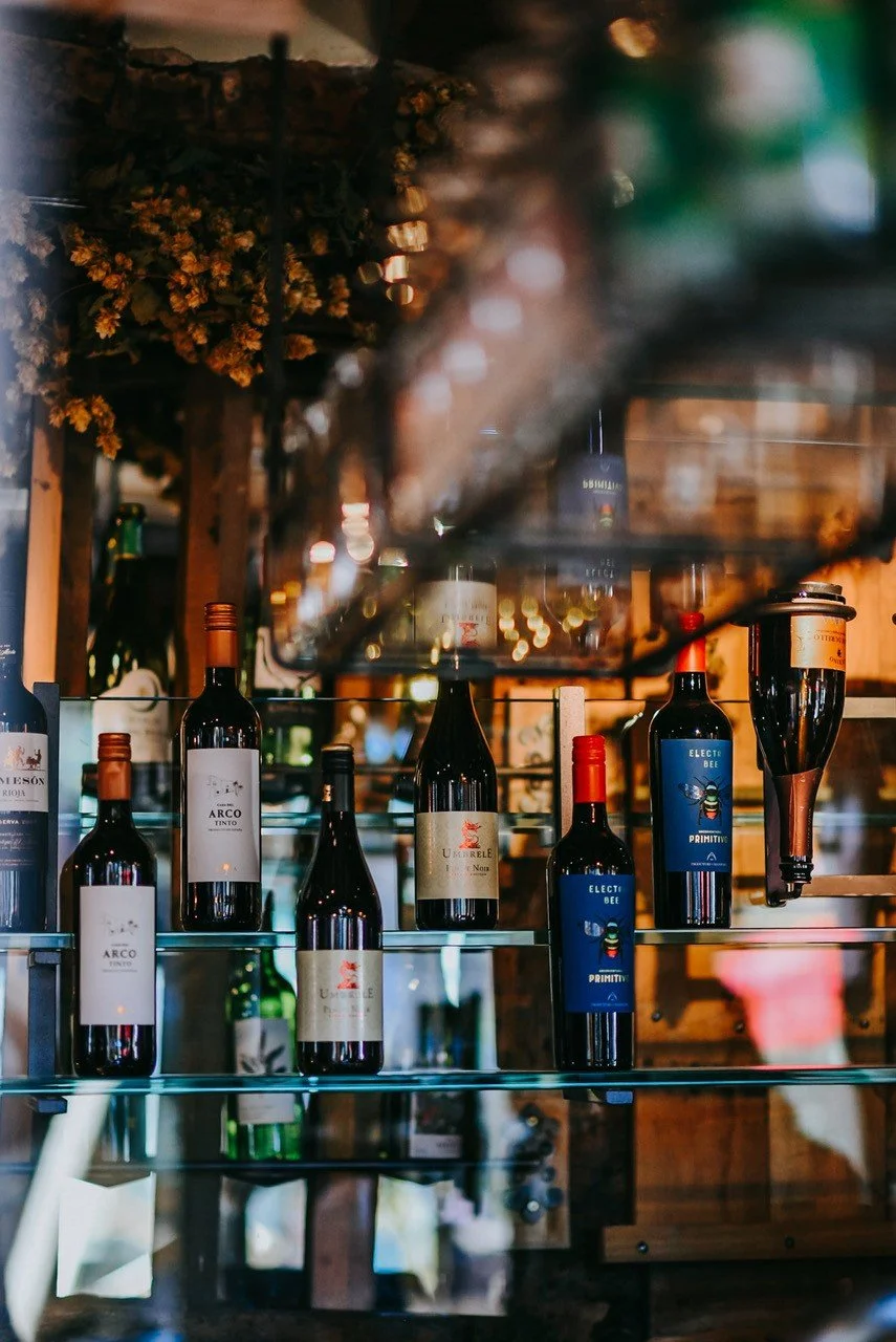 Shelf displaying various bottles of wine in a wine shop or restaurant.